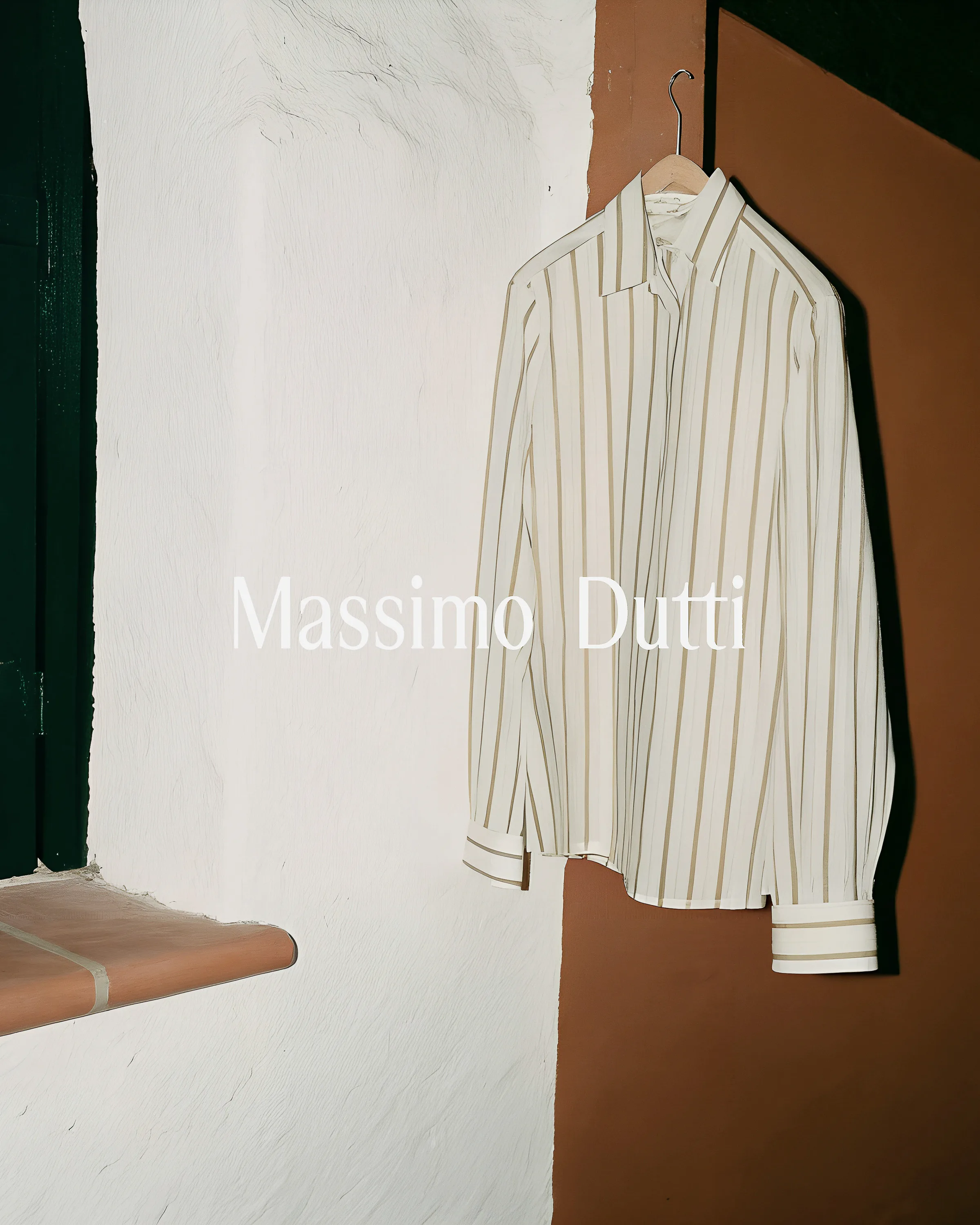 AI image of a cream and tan striped shirt hanging against a white plaster and terracotta wall. Massimo Dutti AI Concept.