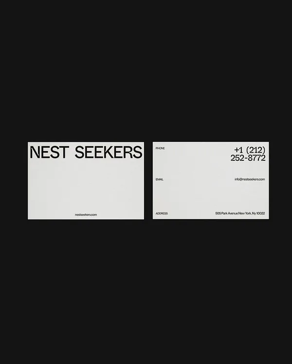 White business cards on black, front with black wordmark and back with phone, email and Park Avenue address, for Nest Seekers.