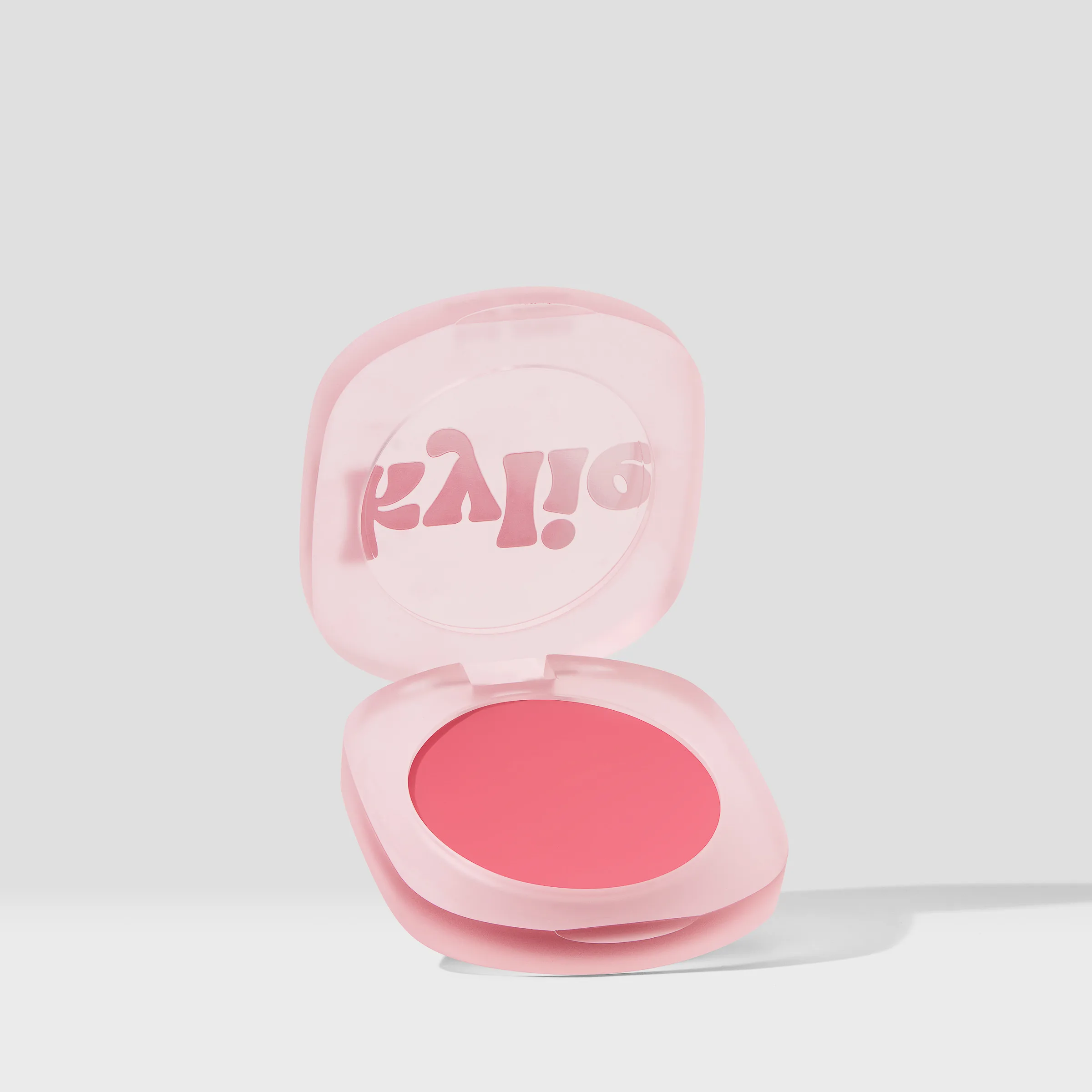Open frosted pink blush compact with coral pressed powder on a light grey background, for Kylie Cosmetics.