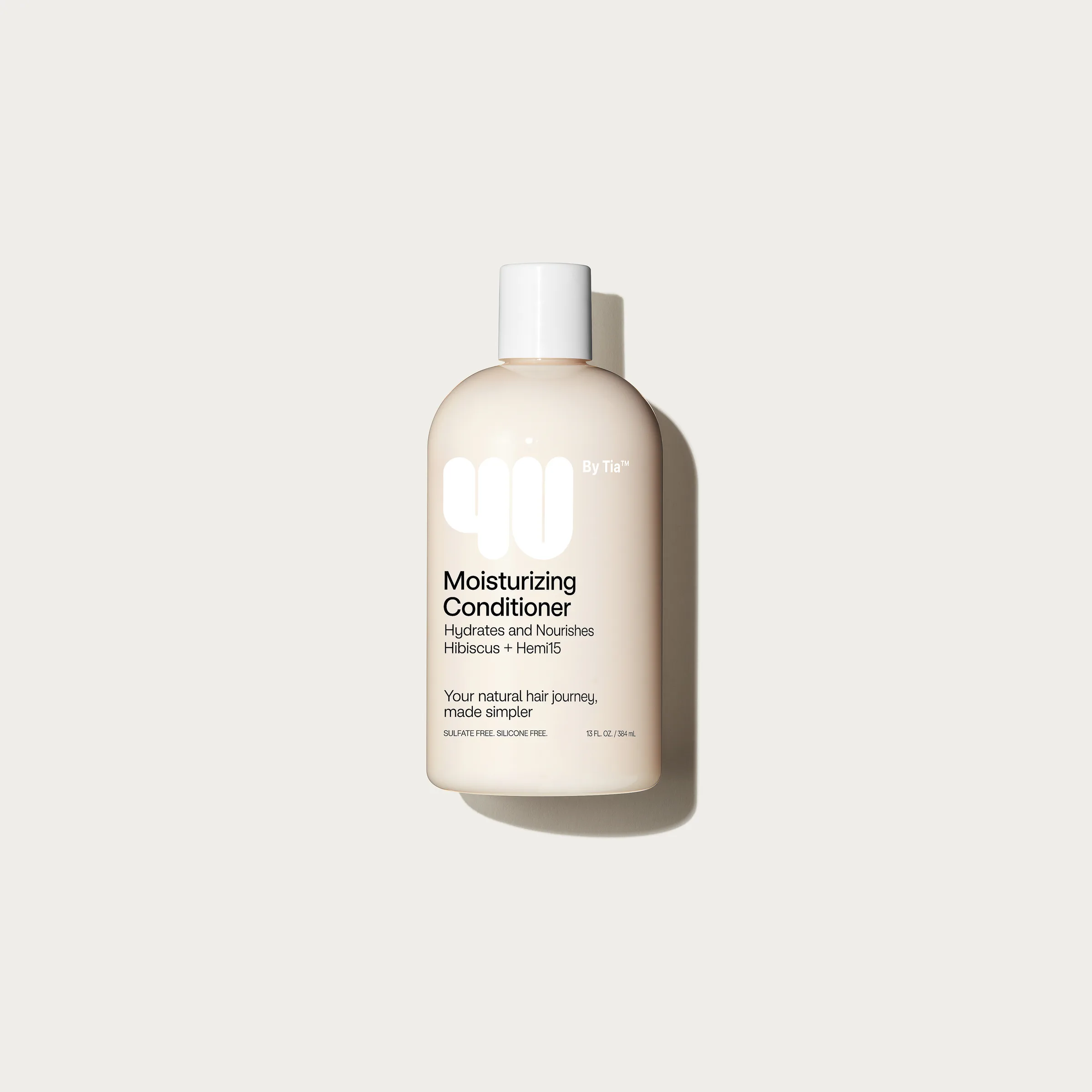 Cream bottle of moisturizing conditioner with white cap on an off-white background, top-down view, for 4U By Tia.