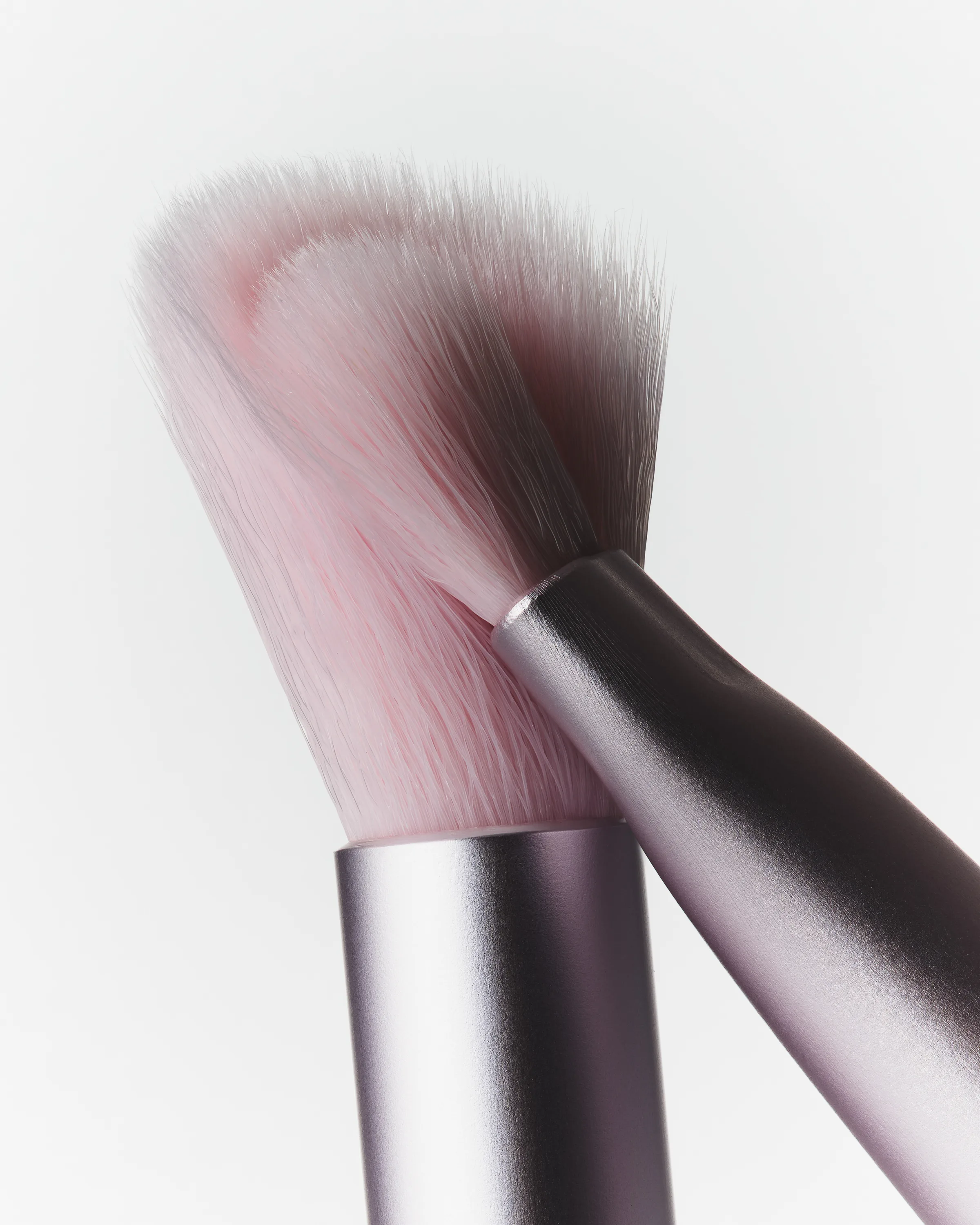 Close-up of two pink makeup brushes with soft bristles and metallic lilac handles on a white background, for Kylie Cosmetics.