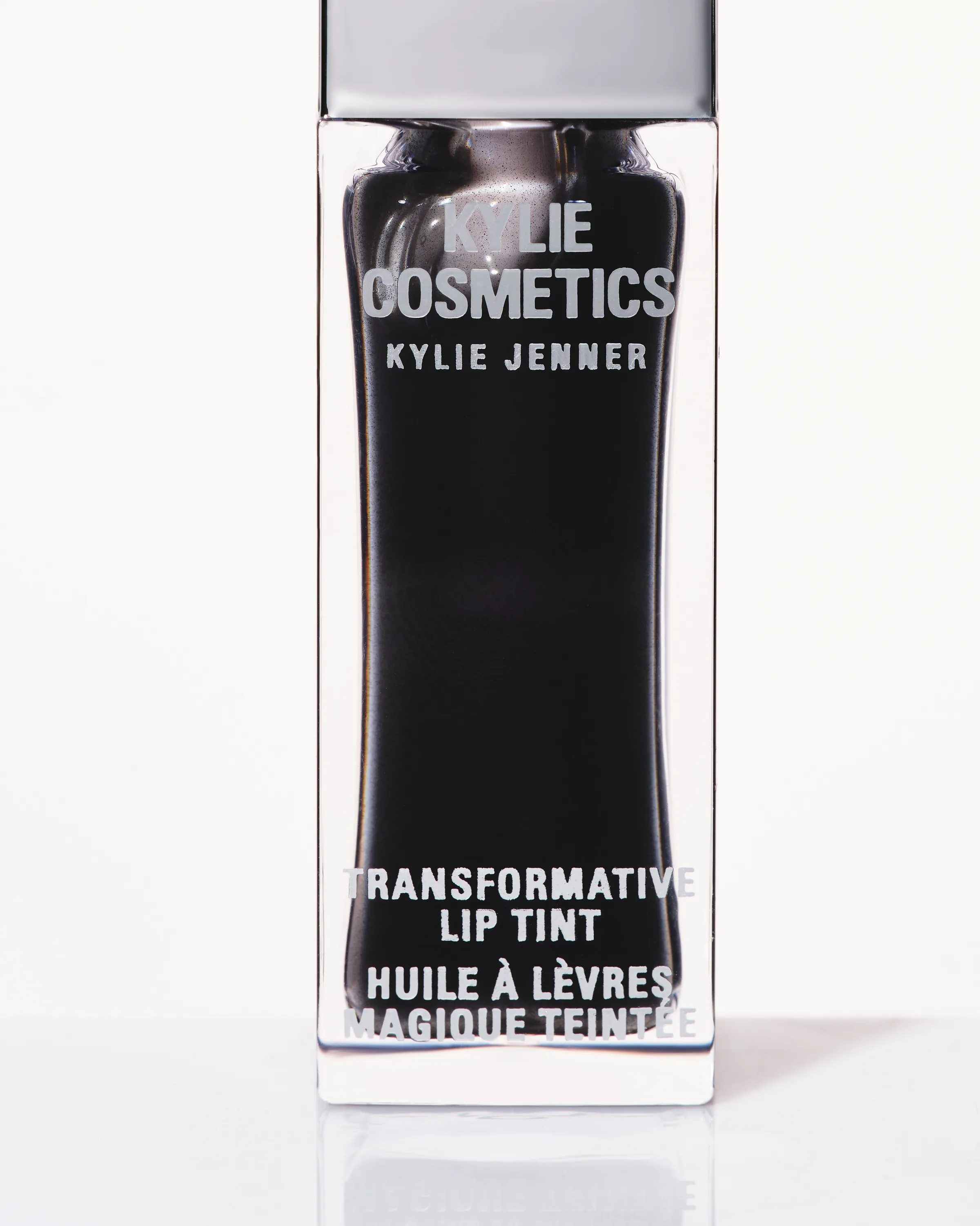Close-up of a Noir Transformative Lip Tint bottle with a silver cap on a white background, for Kylie Cosmetics.