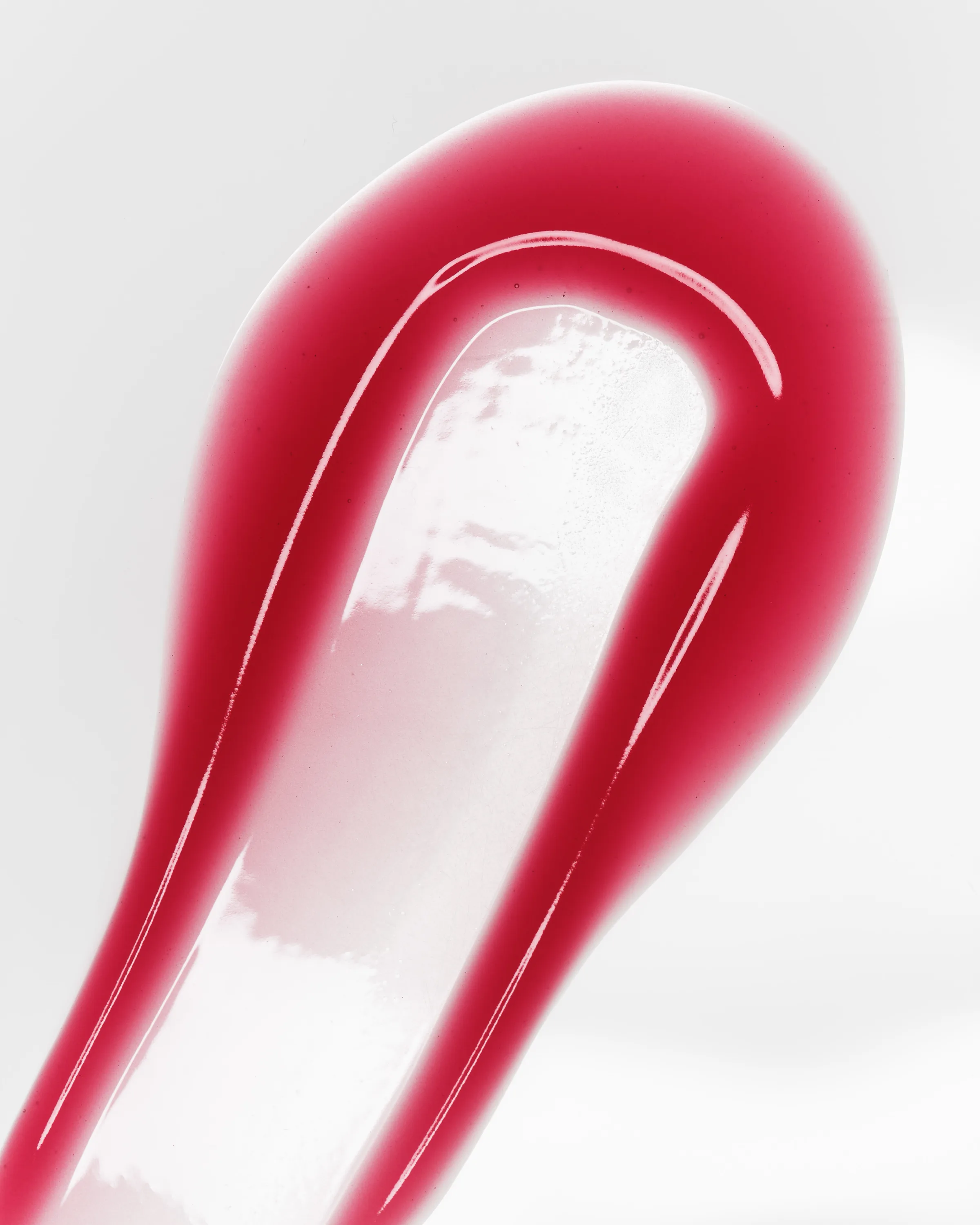Close-up swatch of glossy berry-red lip gloss smeared on a white surface, for Kylie Cosmetics.