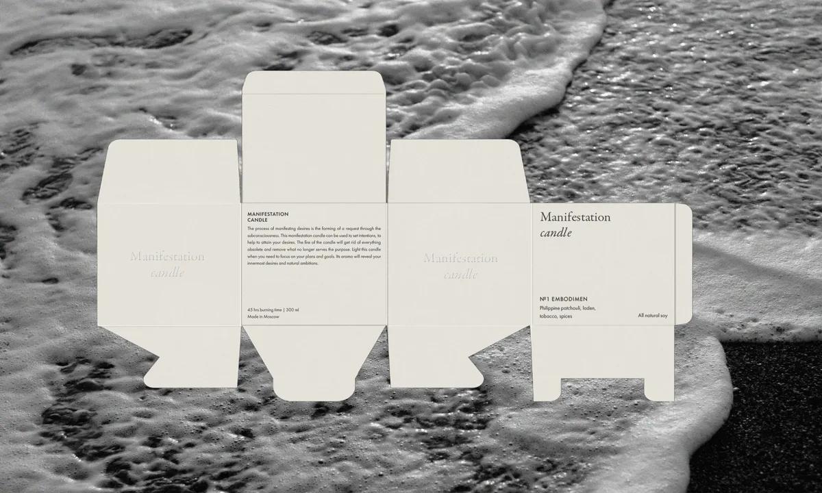 Unfolded cream candle box dieline with serif type and product text, laid over a black-and-white sea foam photo, for Manifestation.