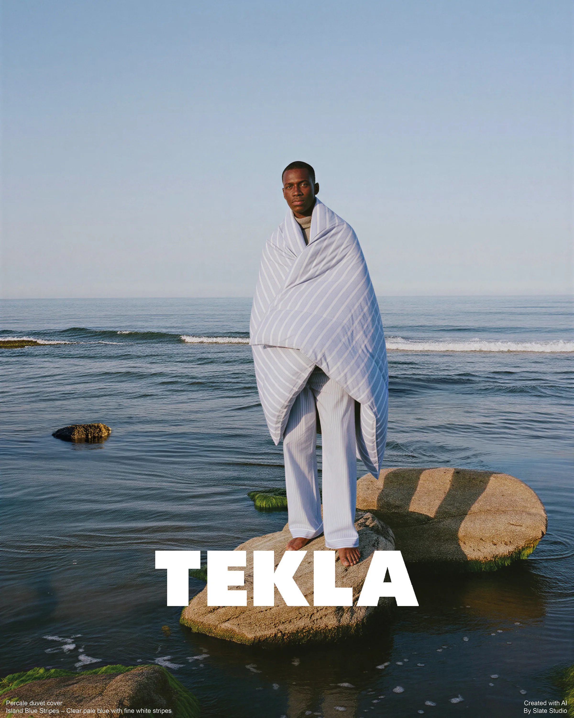 AI image of a man wrapped in a pale blue striped percale duvet, standing barefoot on a rock in the sea. Tekla AI Concept.