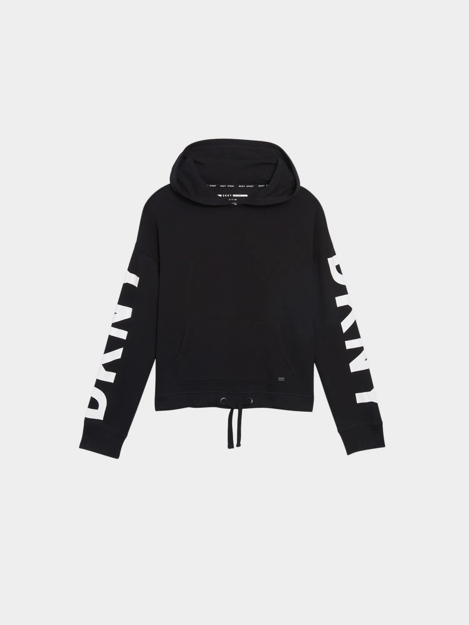 Black cropped hoodie with white DKNY lettering down the sleeves and a drawstring hem, flat lay on white, for DKNY.