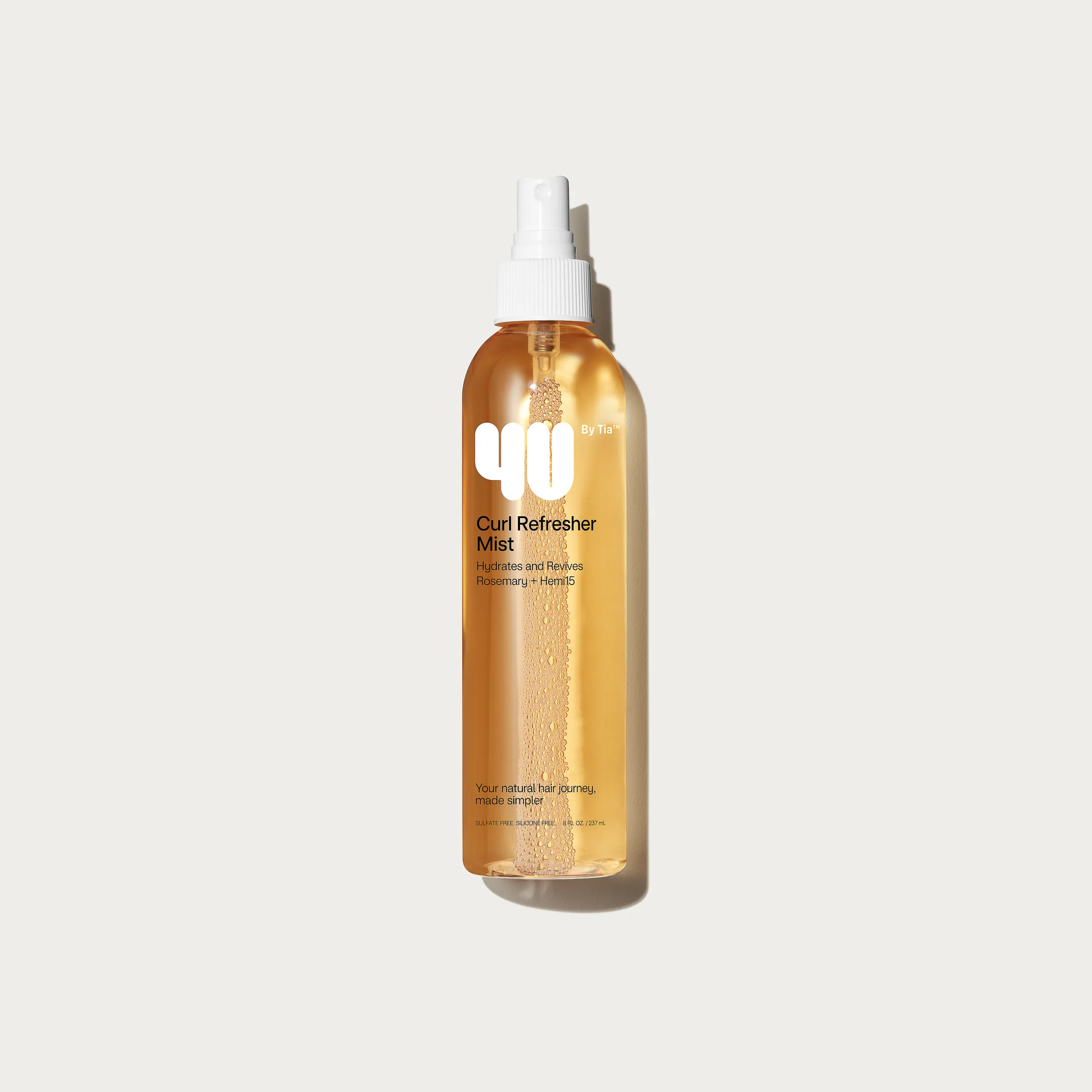 Amber Curl Refresher Mist spray bottle with water droplets on a light grey background, for 4U By Tia.
