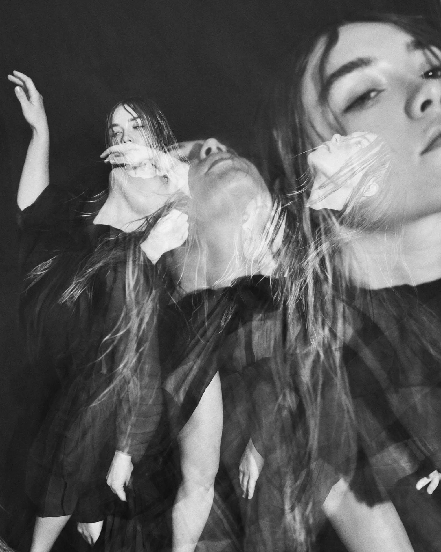 Black and white multiple-exposure portrait of a long-haired model in a dark dress moving against black, for The Last Magazine.