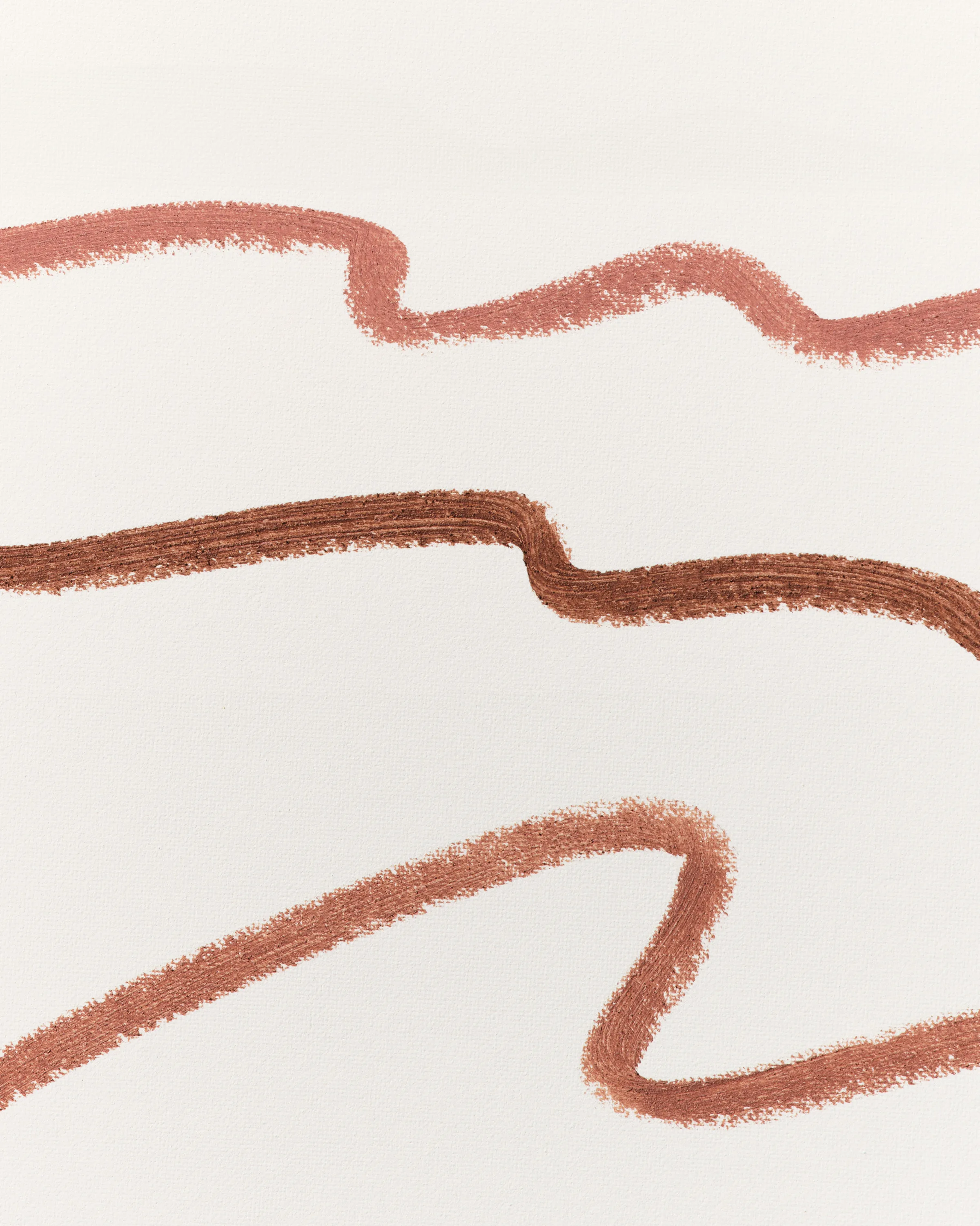 Three wavy lip liner swatches in nude, brown and terracotta shades on textured white paper, for Kylie Cosmetics.