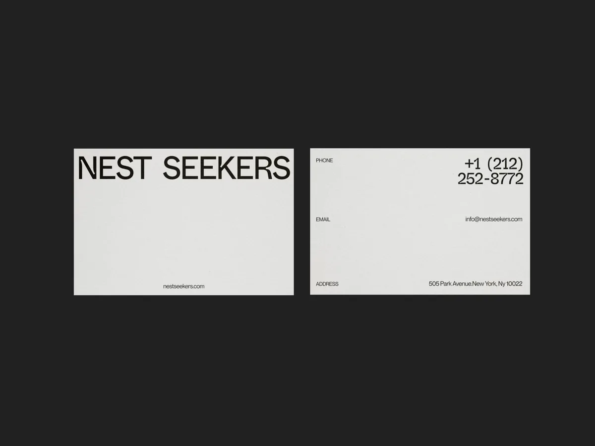Front and back of white business cards with black wordmark and contact details on a dark background, for Nest Seekers.