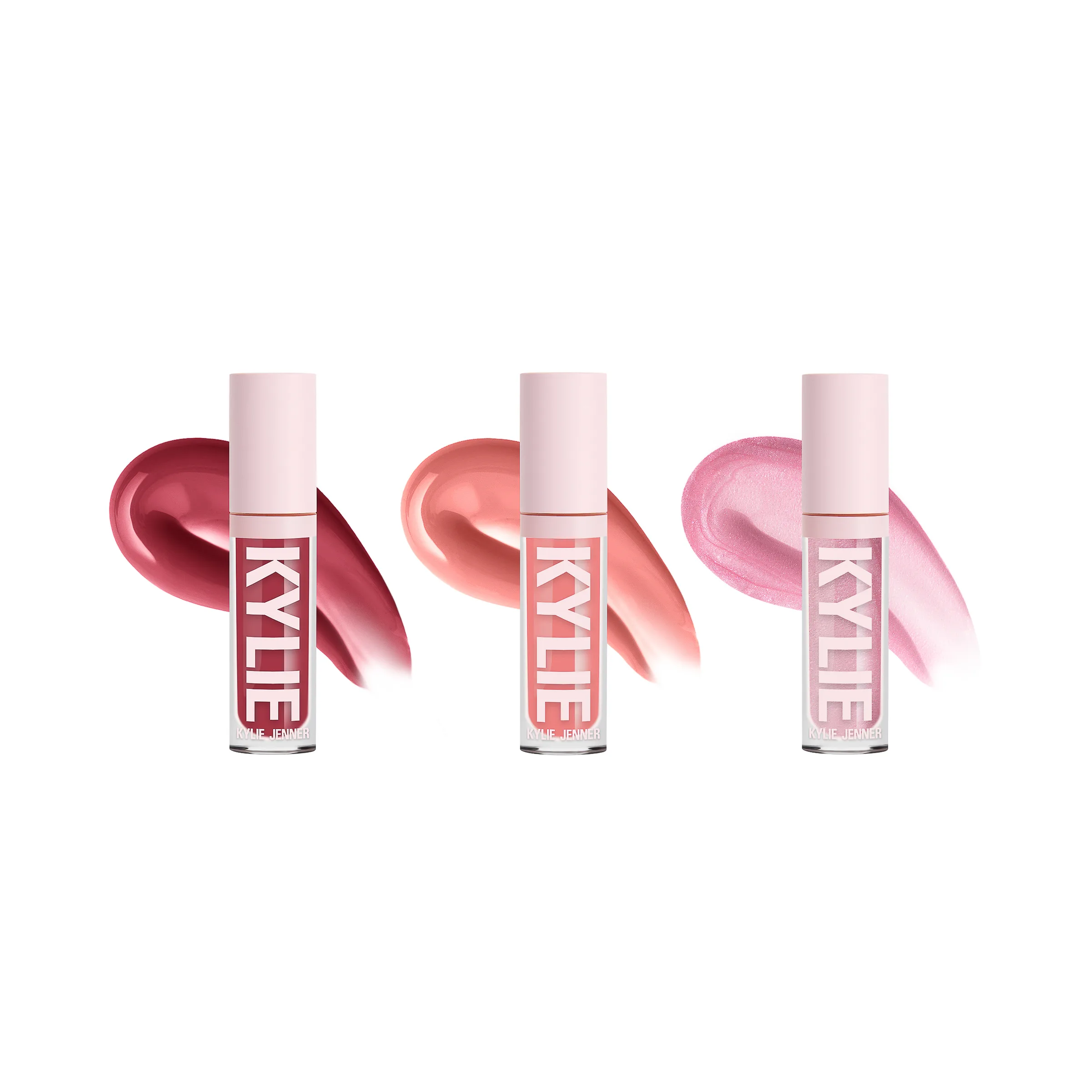 Three pink-capped lip gloss tubes in berry, peach and shimmer pink with matching swatches on white, for Kylie Cosmetics.
