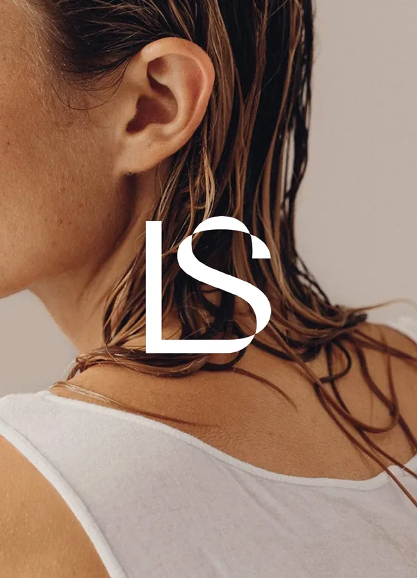White LS monogram over a close-up of a woman's neck and wet hair, wearing a white tank top, for Lightsaver.