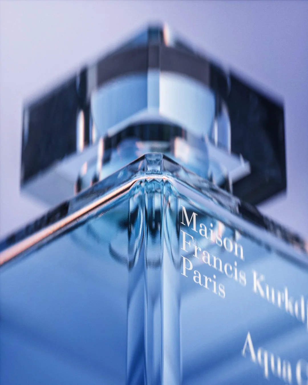 CGI render of a blue glass Aqua perfume bottle and faceted cap in low-angle close-up, for Maison Francis Kurkdjian.