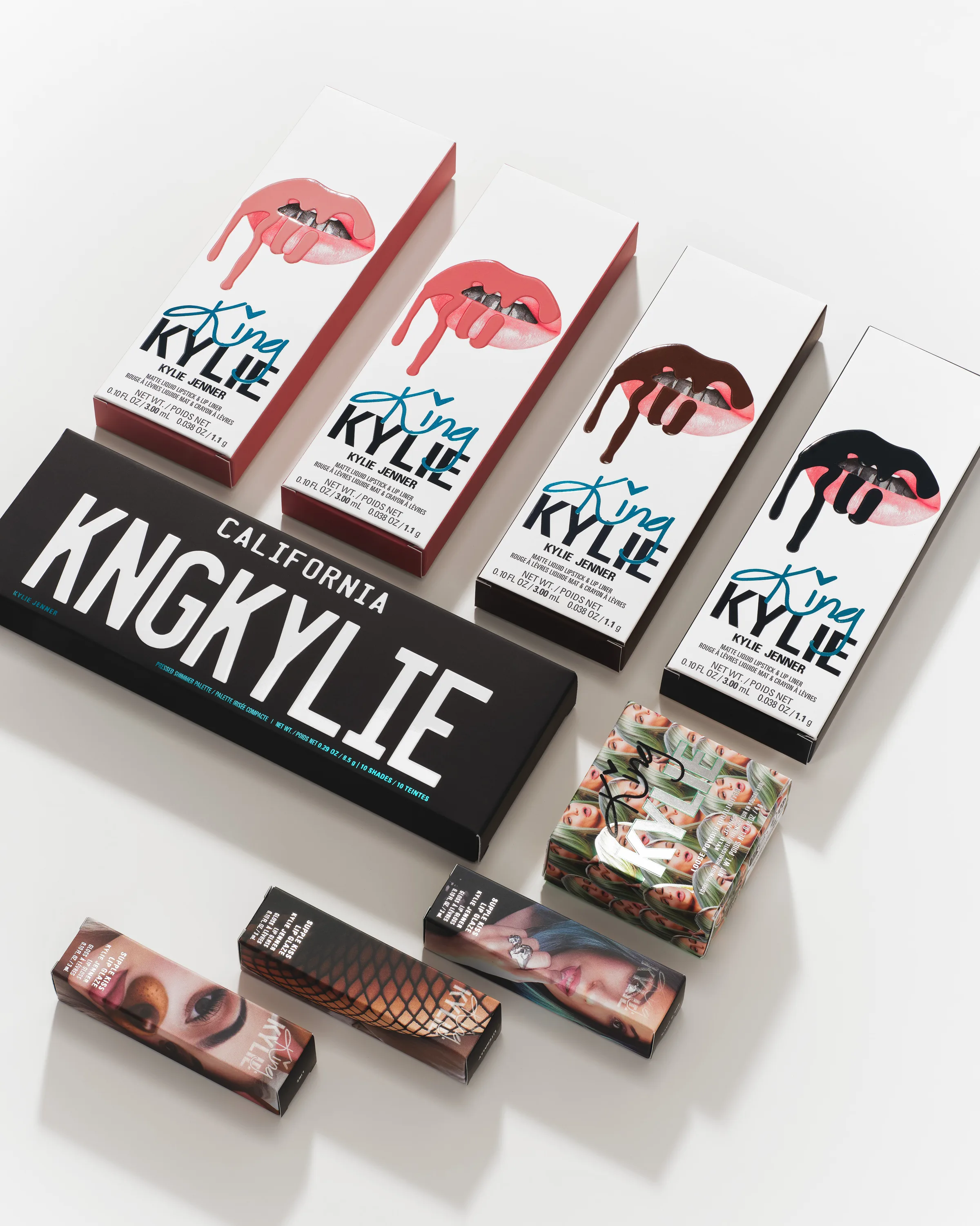 Still life of King Kylie lip kit boxes, KNGKYLIE palette and lipstick cartons on white, for Kylie Cosmetics.
