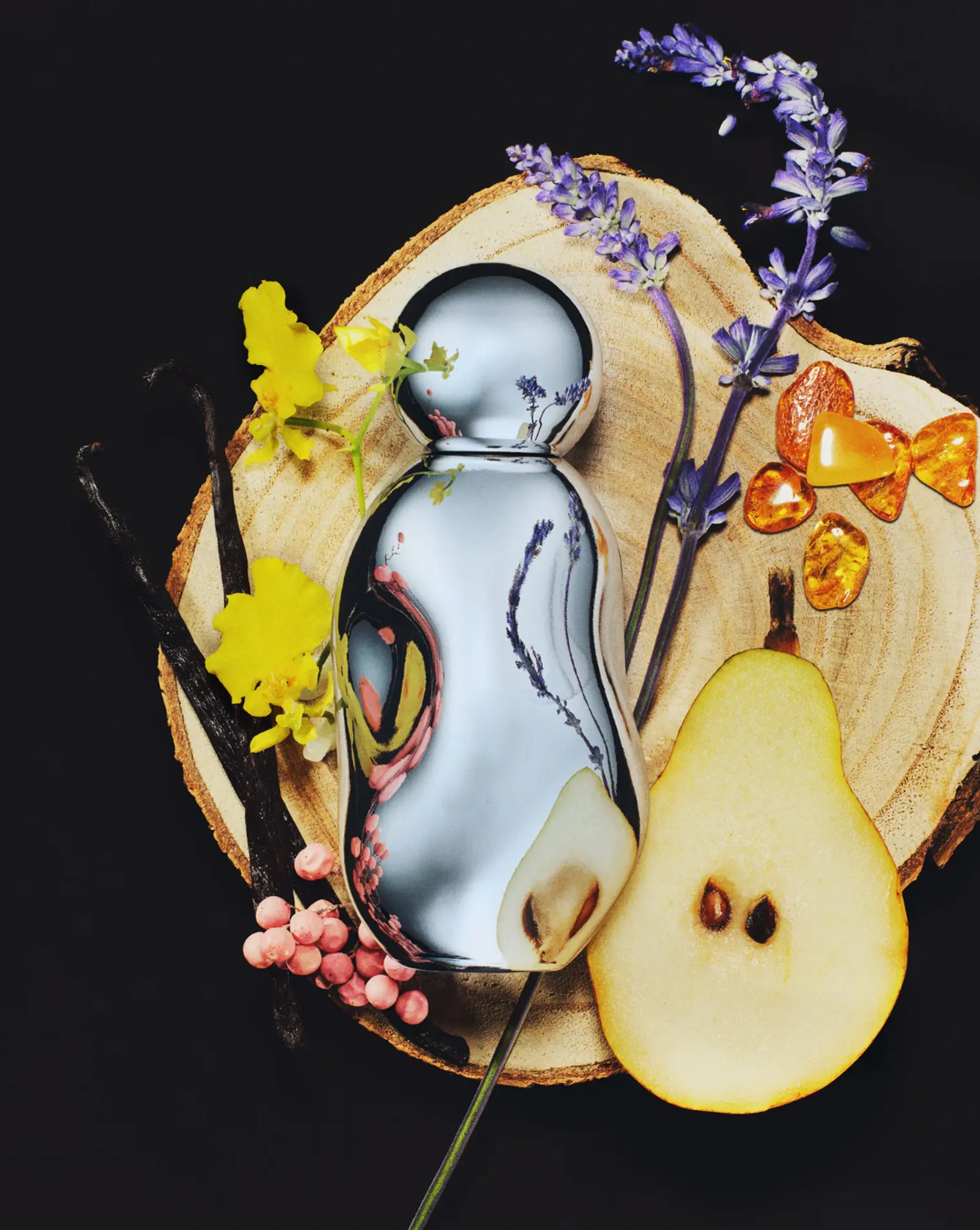 Chrome perfume bottle on a wood slice with halved pear, lavender, vanilla pods, amber and pink peppercorns, for Kylie Cosmetics.