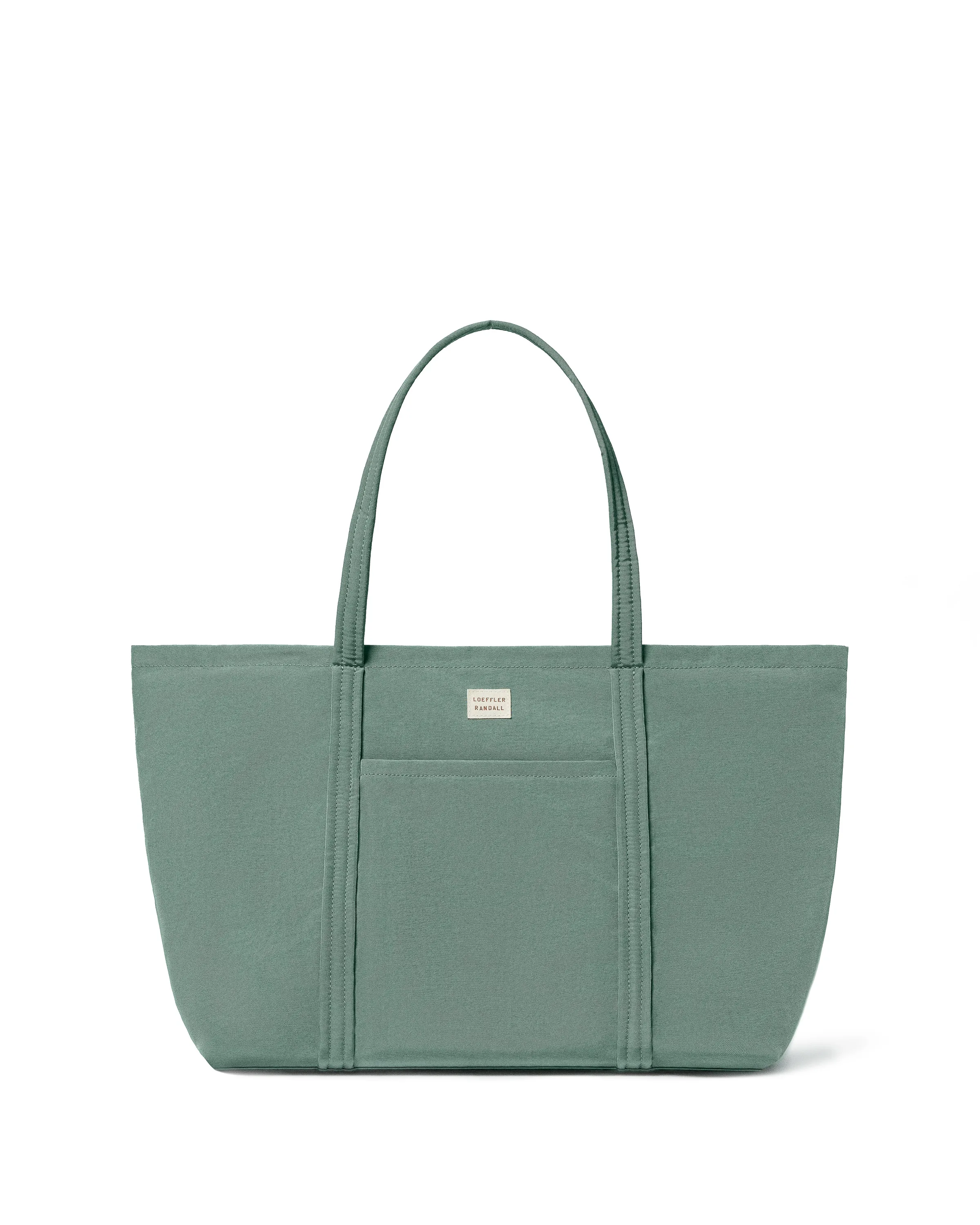 Sage green canvas tote bag with front pocket and long straps on a white background, for Loeffler Randall.