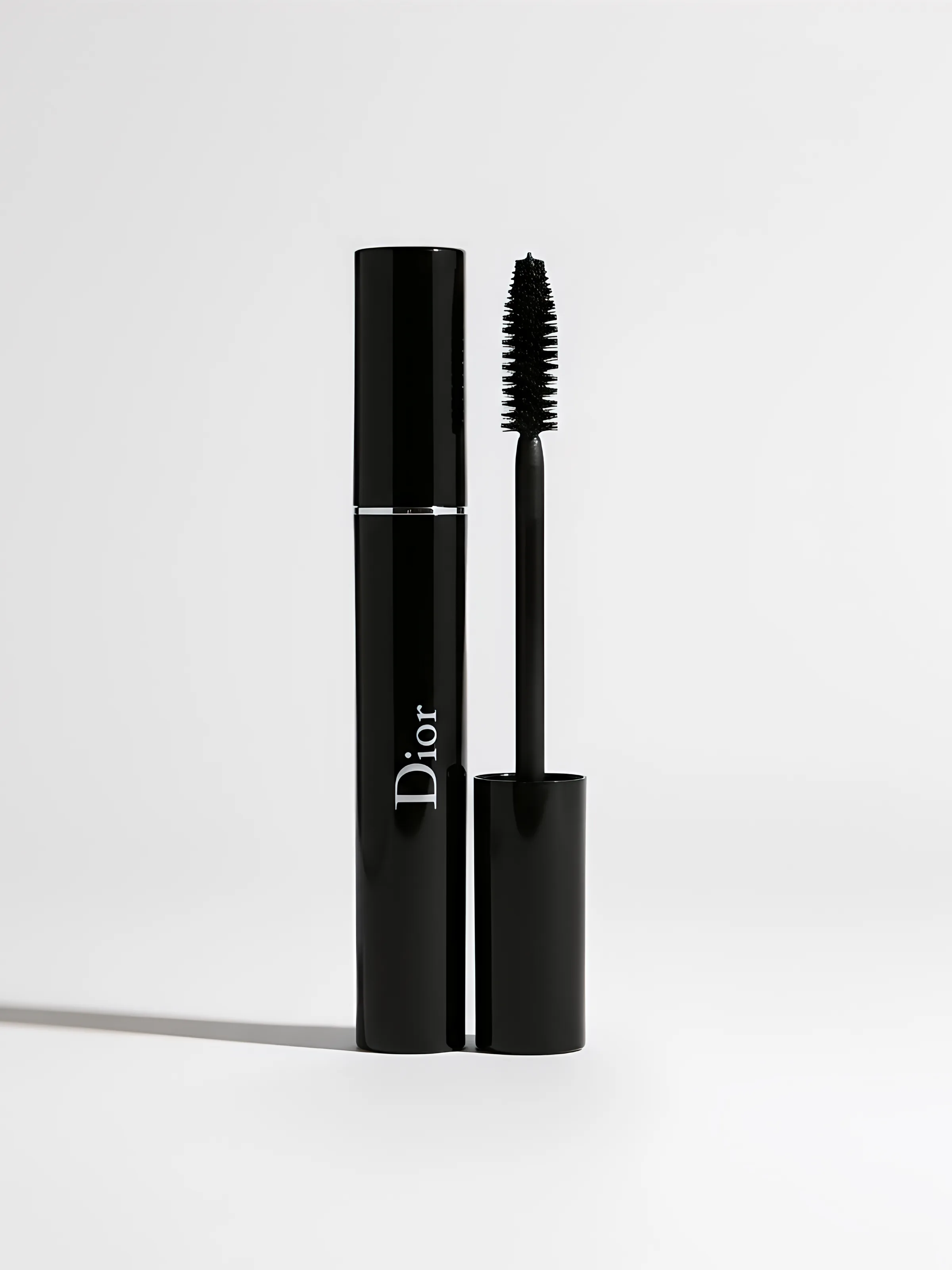 AI image of a black mascara tube beside its upright brush wand on a white background. Dior AI Concept.