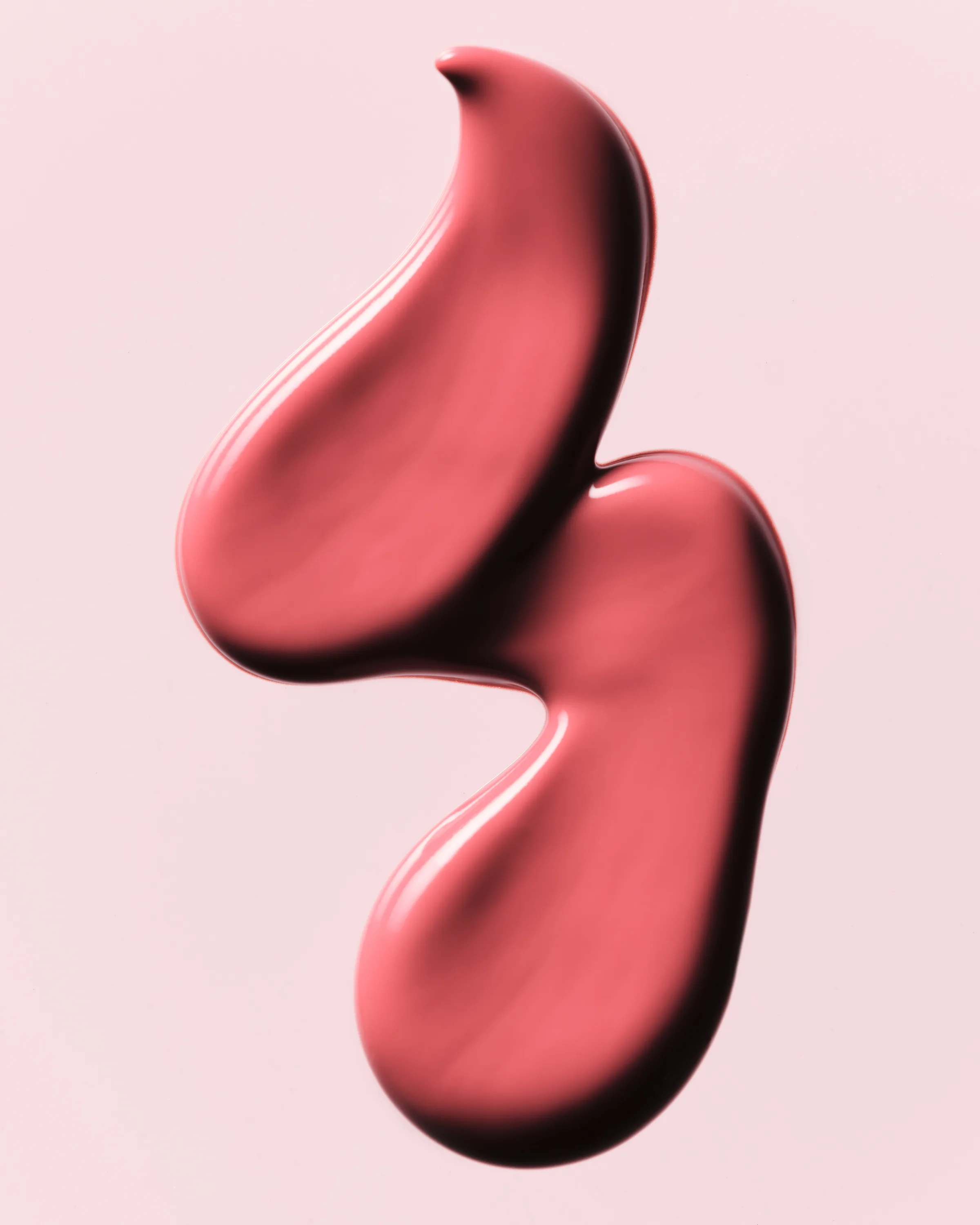 Glossy coral-pink cosmetic swatch in an S-shaped swirl on a pale pink background, for Kylie Cosmetics.