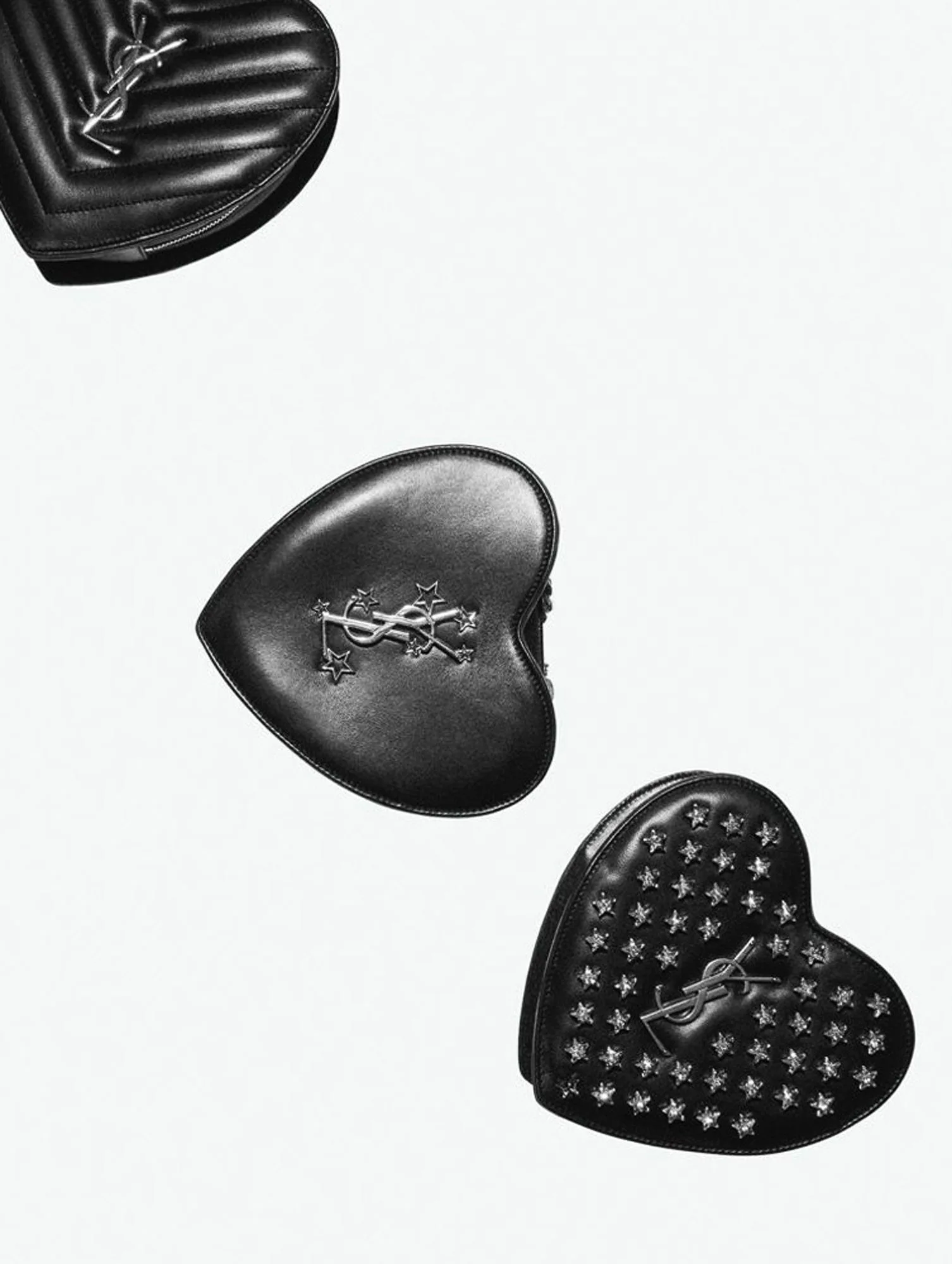 Three black leather heart-shaped YSL bags, quilted, star-embellished and studded, on a white background, for Interview Magazine.