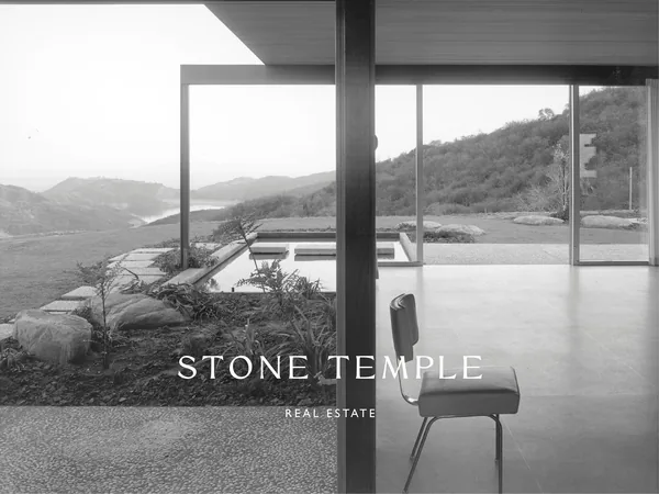 White wordmark over a black-and-white photo of a modernist glass house with a chair, reflecting pool and hills, for Stone Temple.