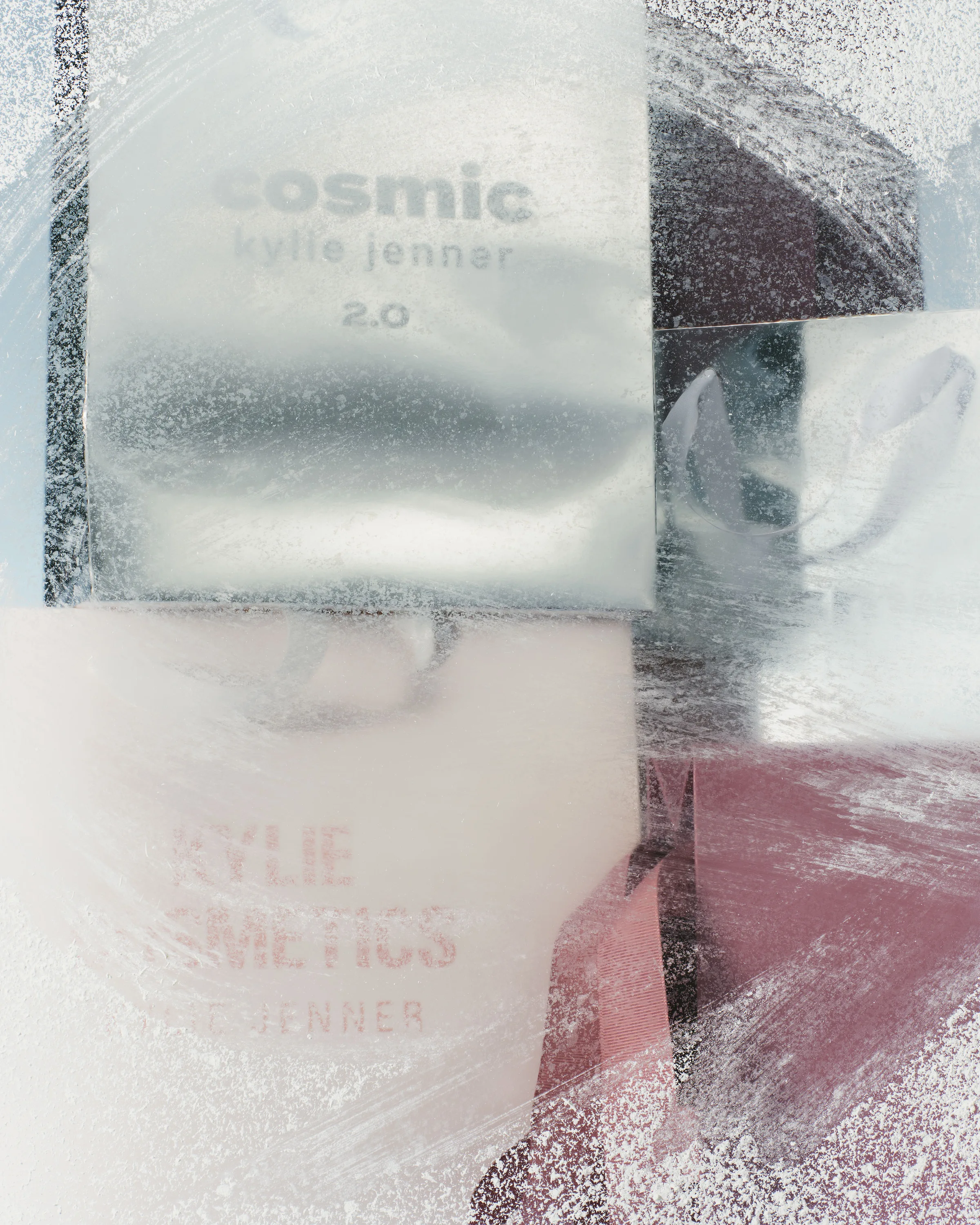 Silver Cosmic Kylie Jenner 2.0 box and pink Kylie Cosmetics bag seen through frosted glass, for Kylie Cosmetics.