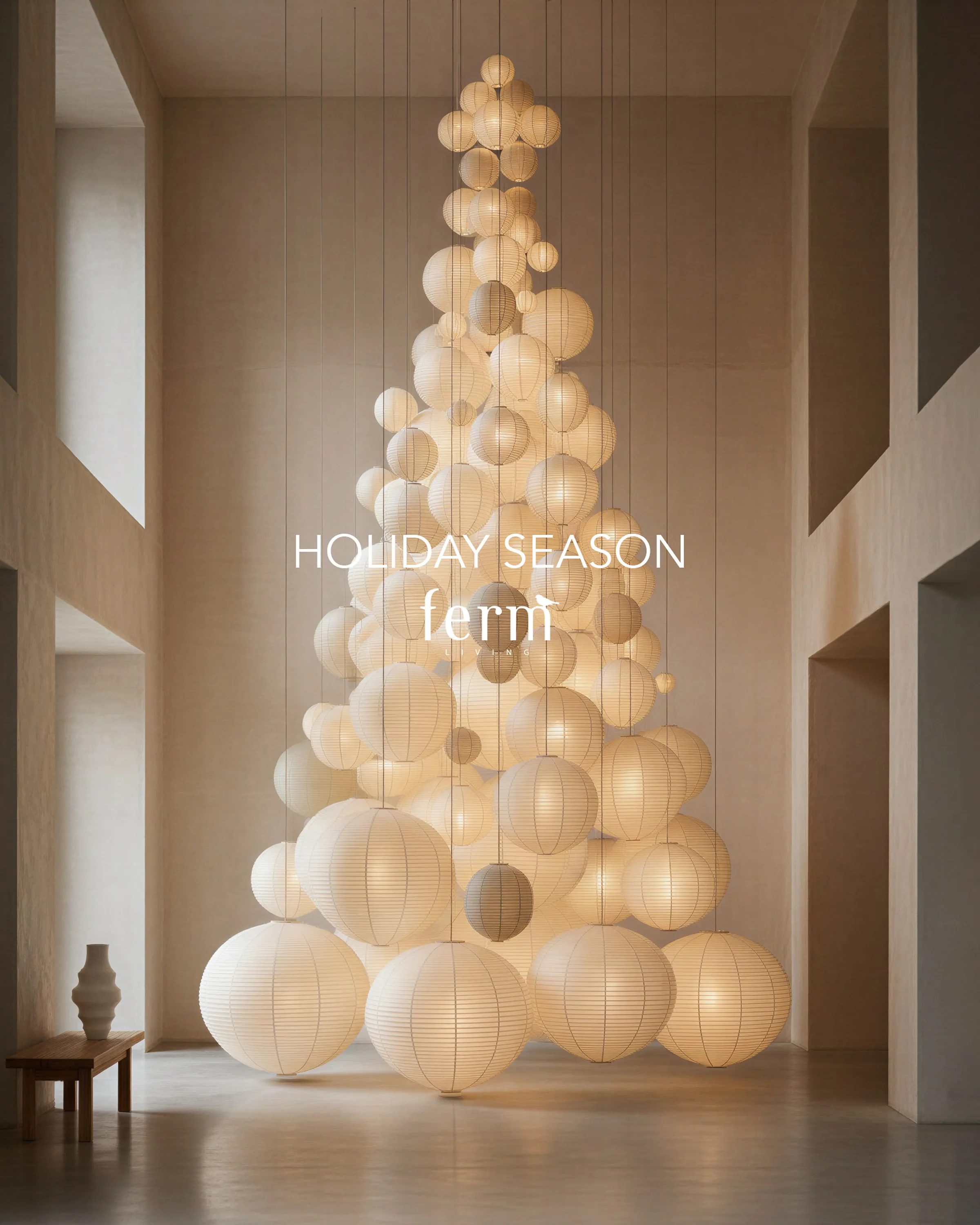 AI image of white paper lanterns stacked into a glowing Christmas tree in a tall minimalist hall. Ferm Living AI Concept.