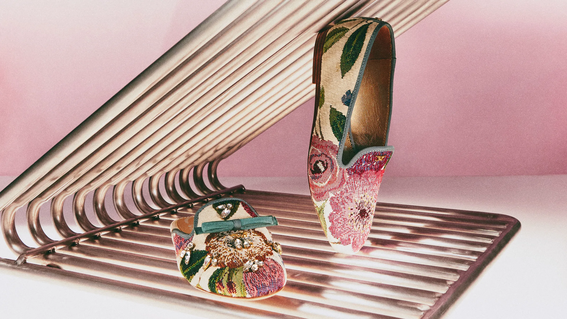 Floral tapestry flats with jewelled bow and loafer style posed on a chrome rack against a pink backdrop, for Sam Edelman.