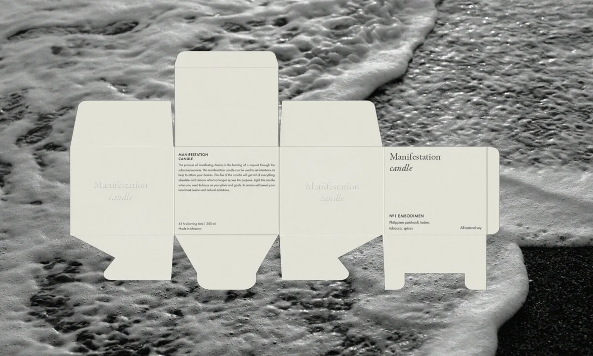 Unfolded cream candle box dieline with serif type and product text, laid over a black-and-white sea foam photo, for Manifestation.