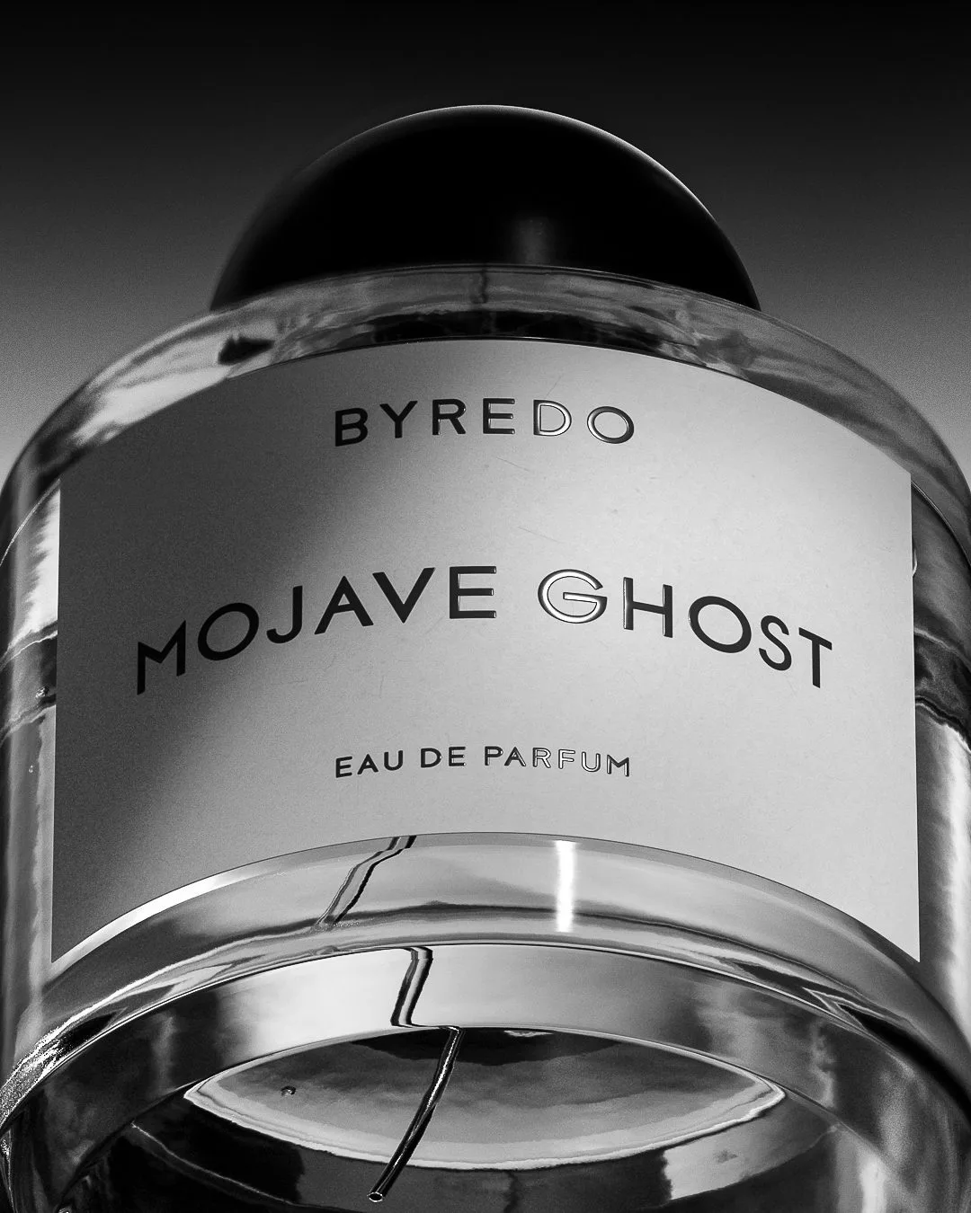 CGI render of a Mojave Ghost eau de parfum bottle in black and white, shot from below against a dark sky, for Byredo.
