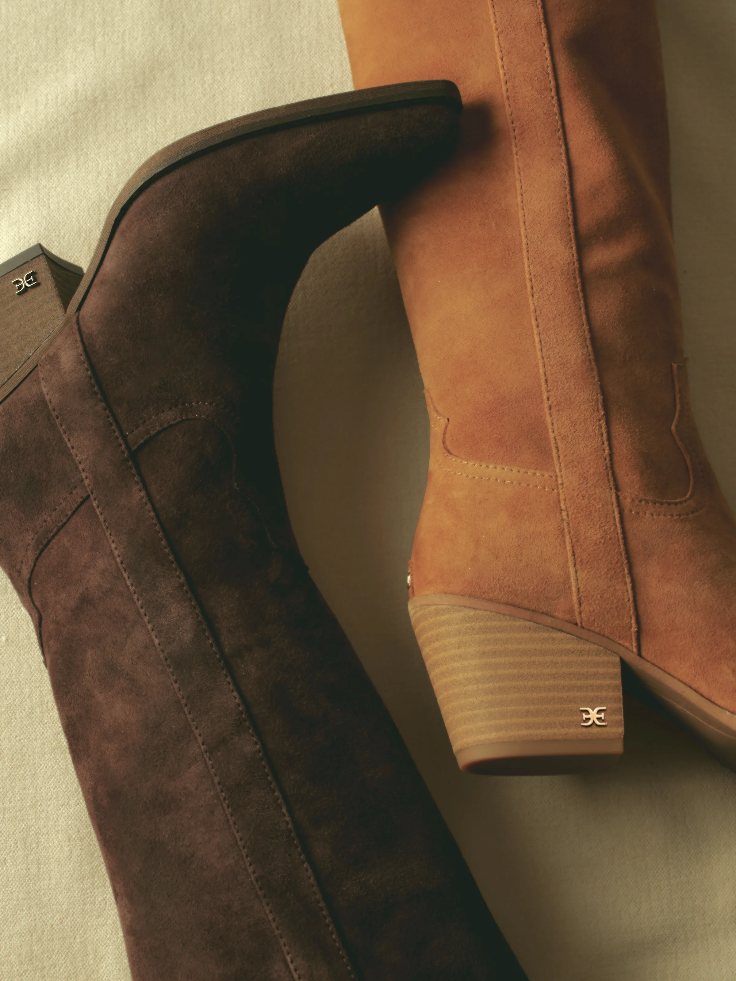Two suede western boots in dark café noir and tan frontier brown with stacked wooden heels, for Sam Edelman.