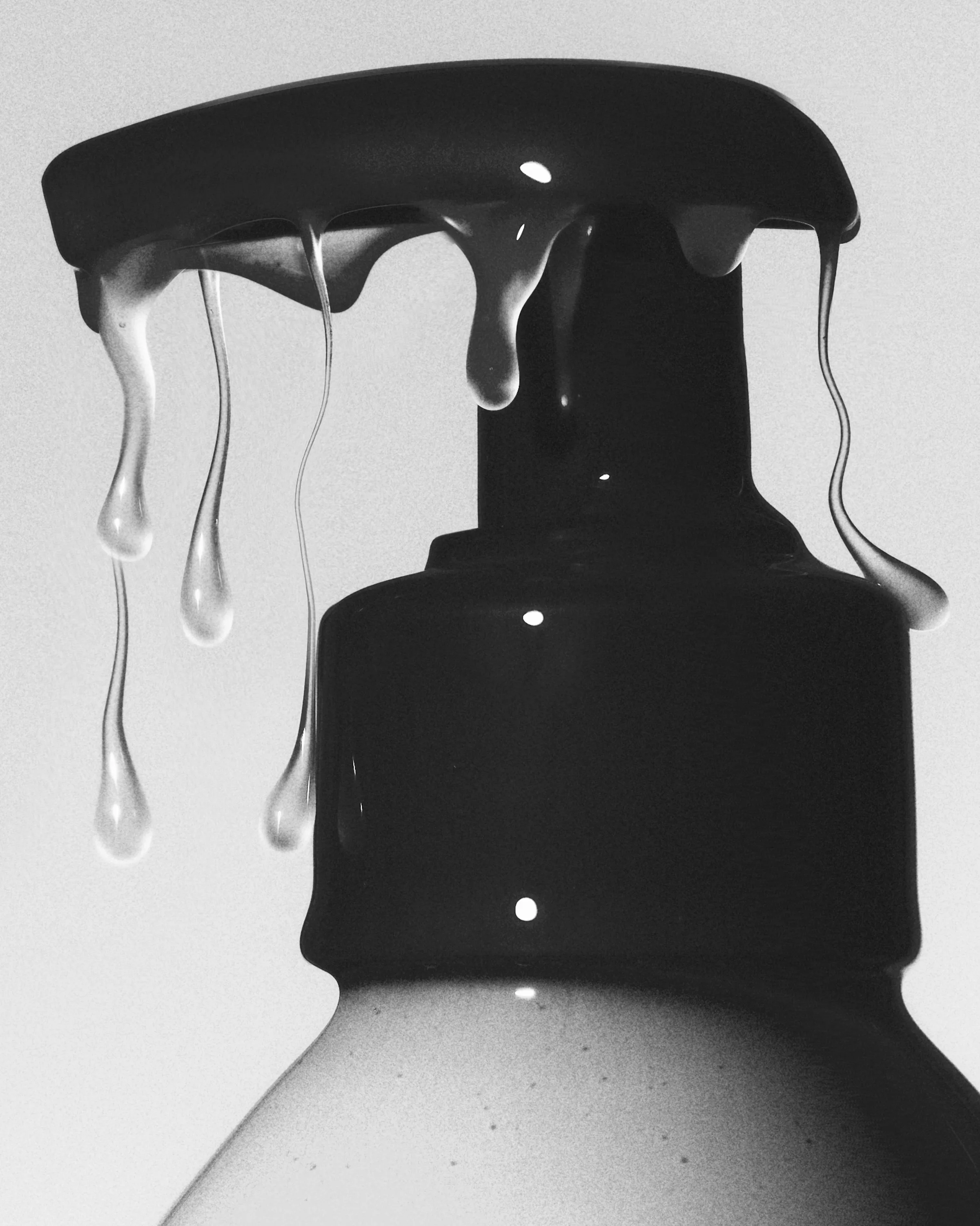 Black-and-white close-up of a pump bottle top with clear gel dripping from the nozzle, for JVN Hair.
