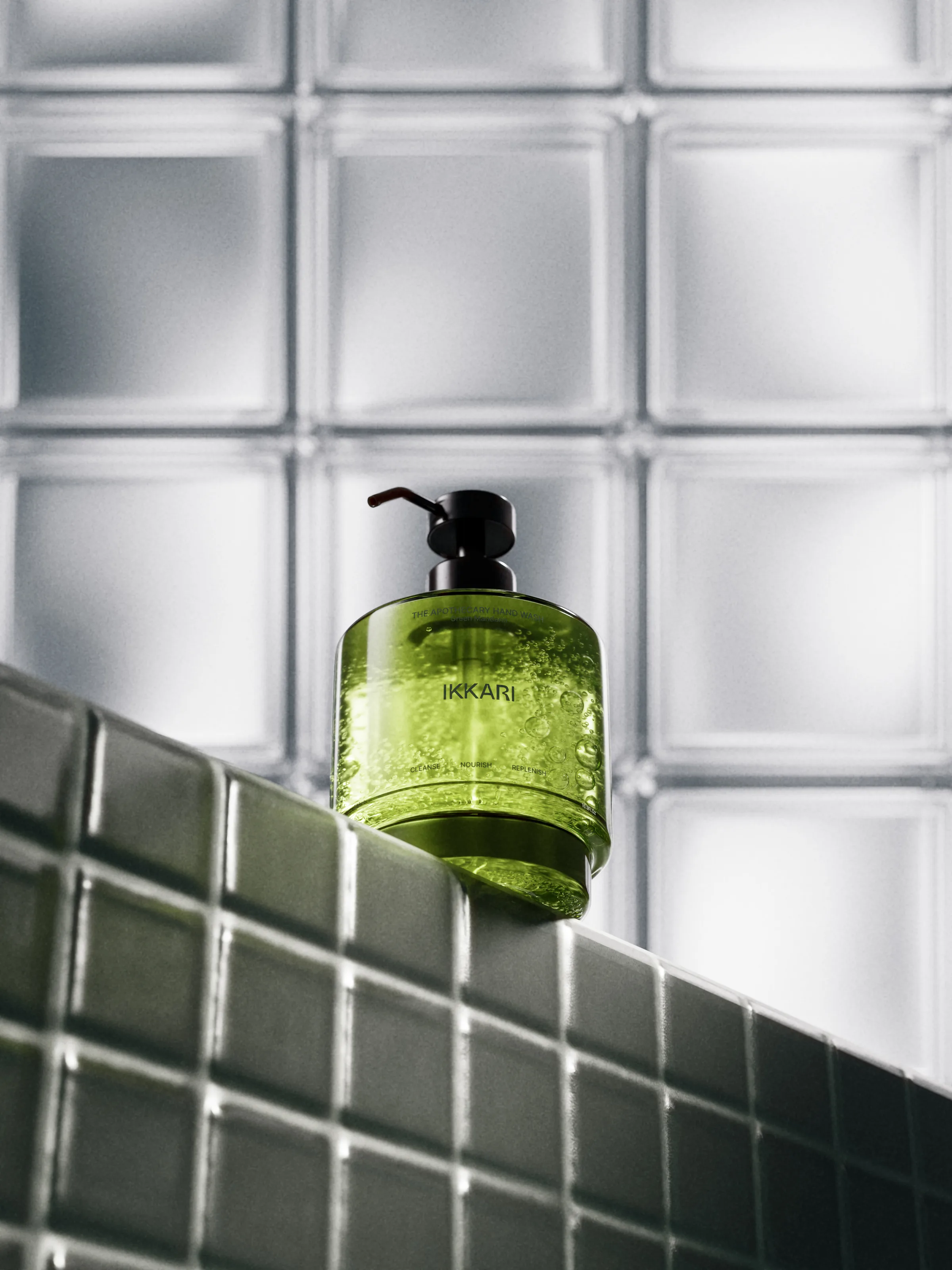CGI render of a green pump bottle on a dark tiled ledge against frosted glass blocks, for Ikkari.