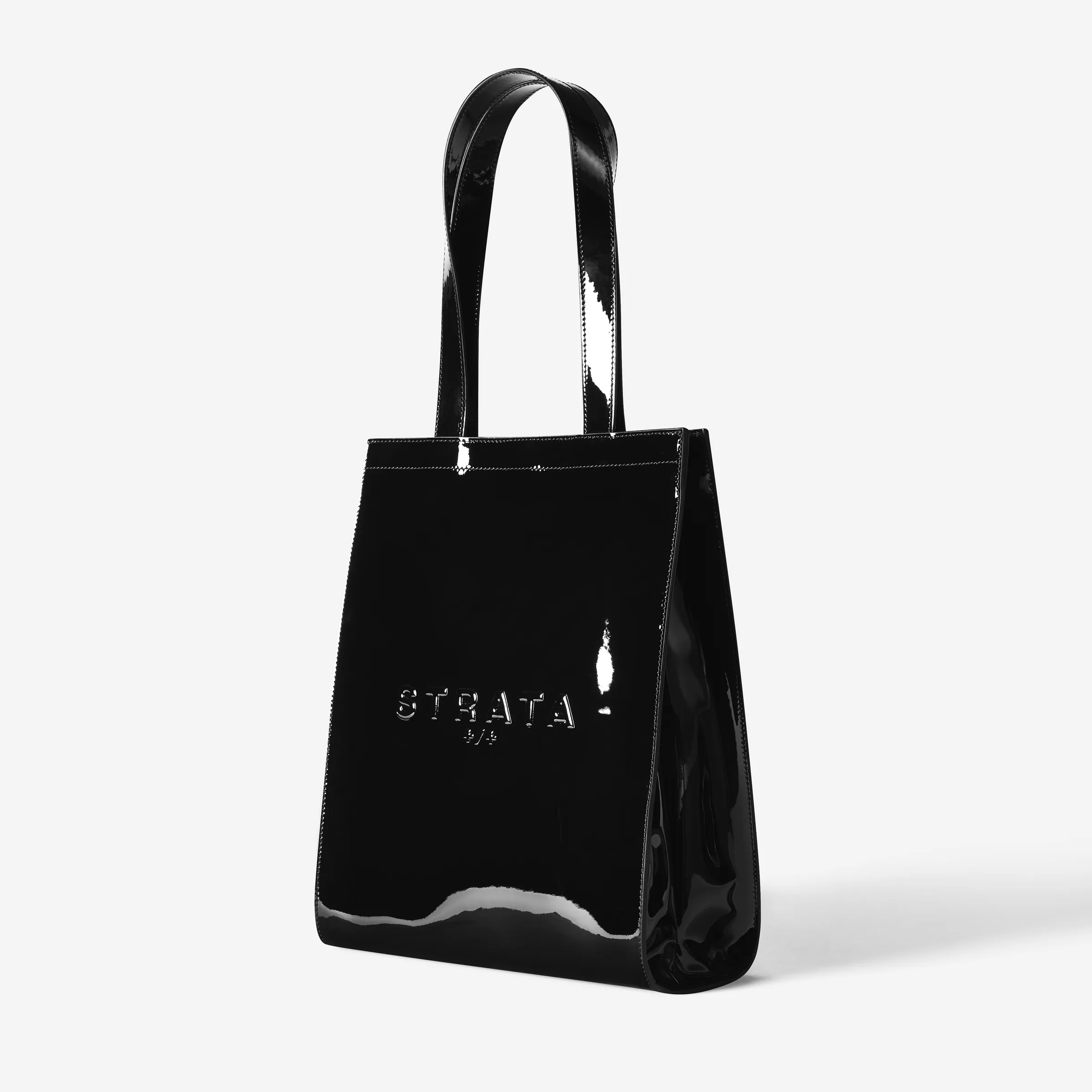 Black patent leather Carmen tote bag with embossed logo, three-quarter view on a white background, for Strata.