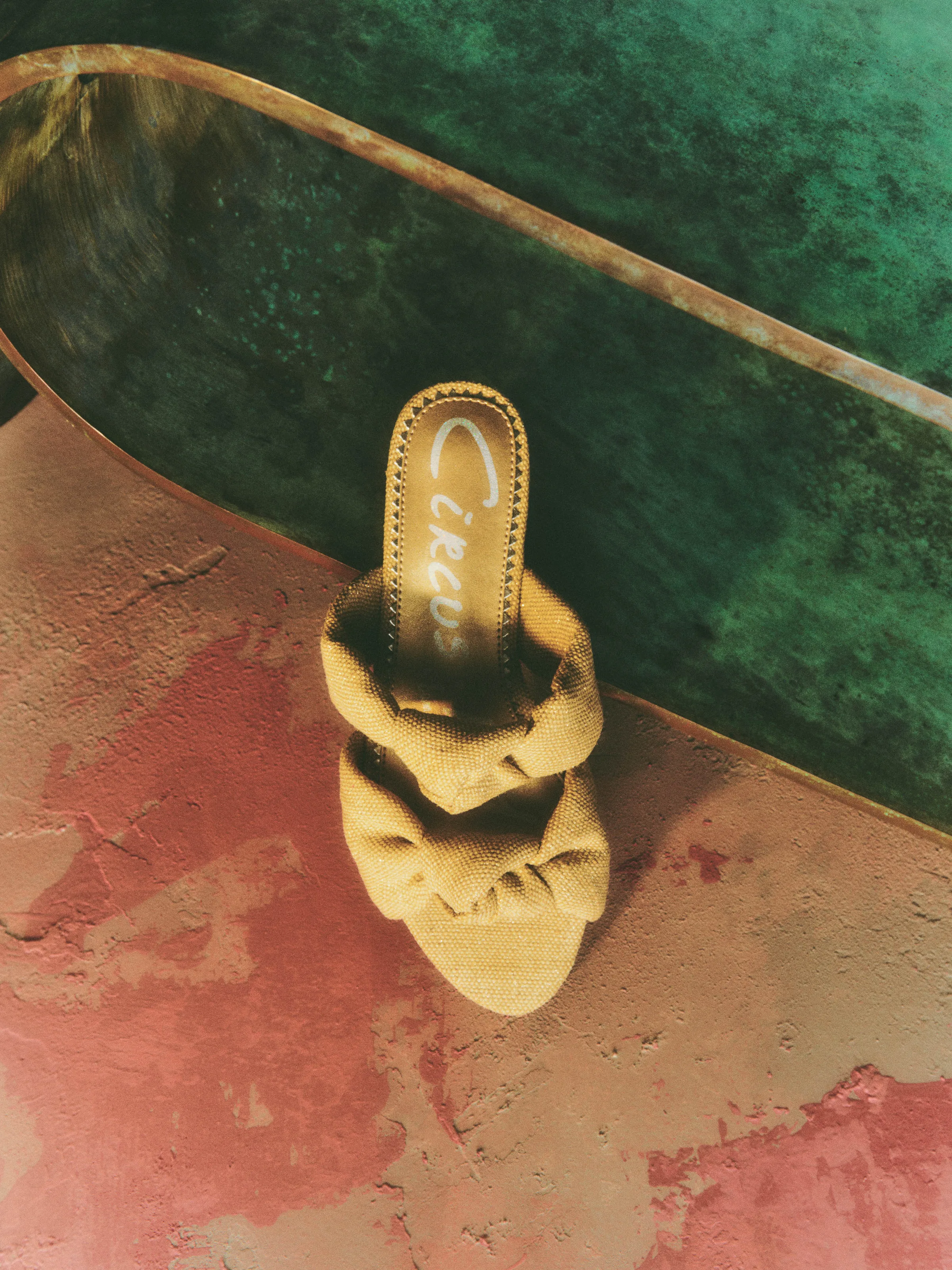Natural canvas mule sandal with double knotted straps on a pink plaster and green marble surface, for Circus NY.