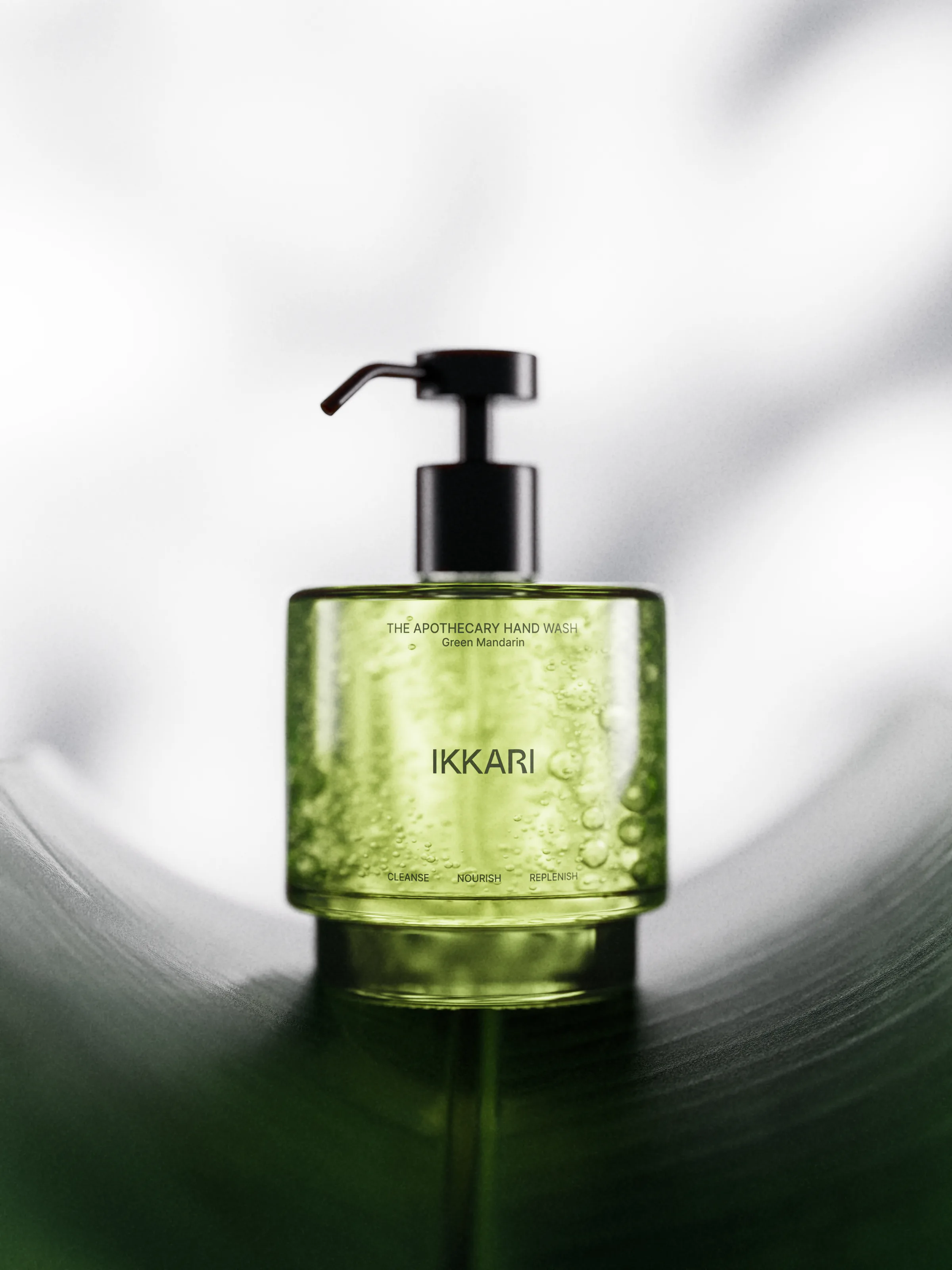 CGI render of a green glass hand wash pump bottle with bubbles, resting on a curved green leaf, for Ikkari.