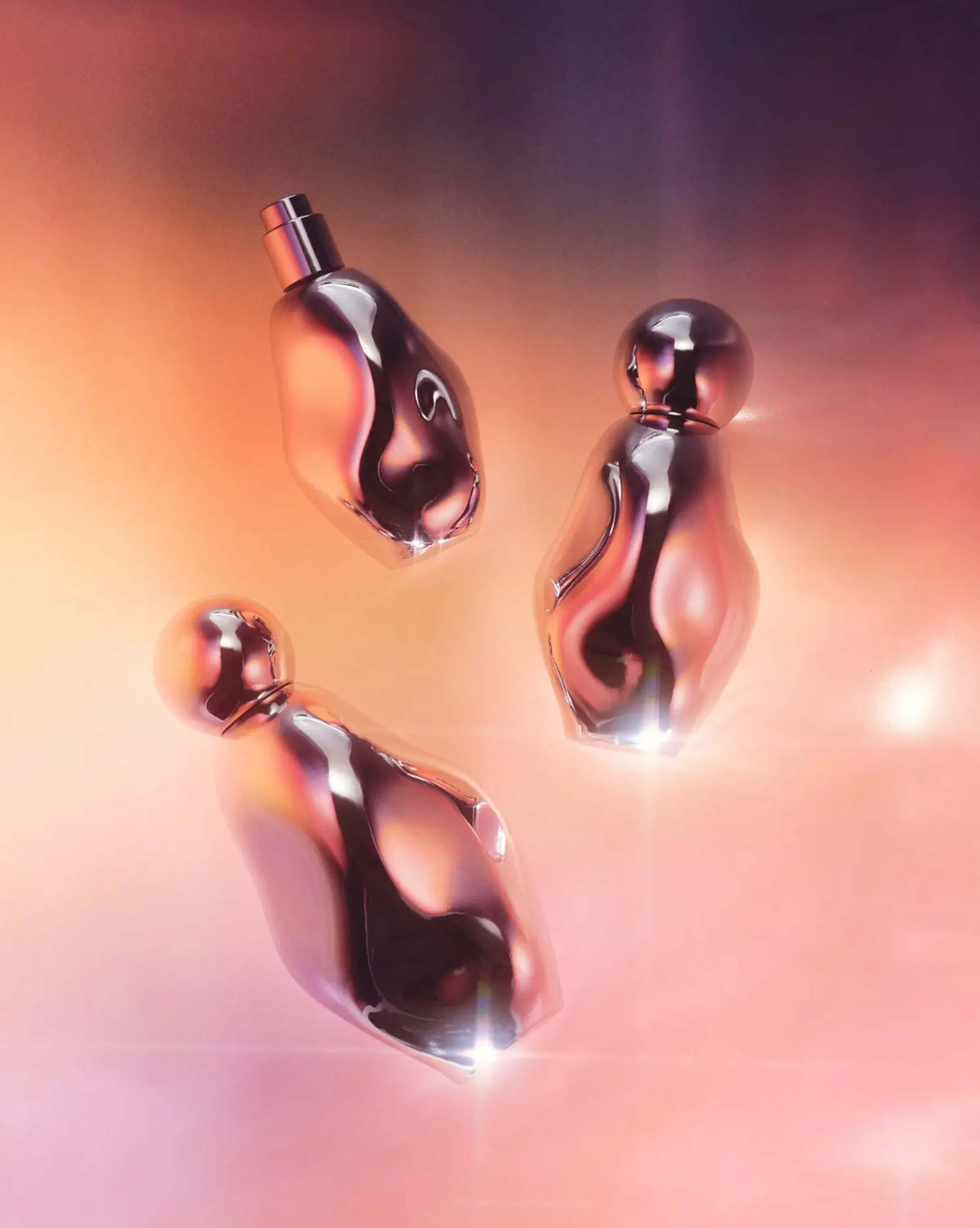 Three sculpted chrome perfume bottles floating against a glowing peach and violet backdrop, for Kylie Cosmetics.