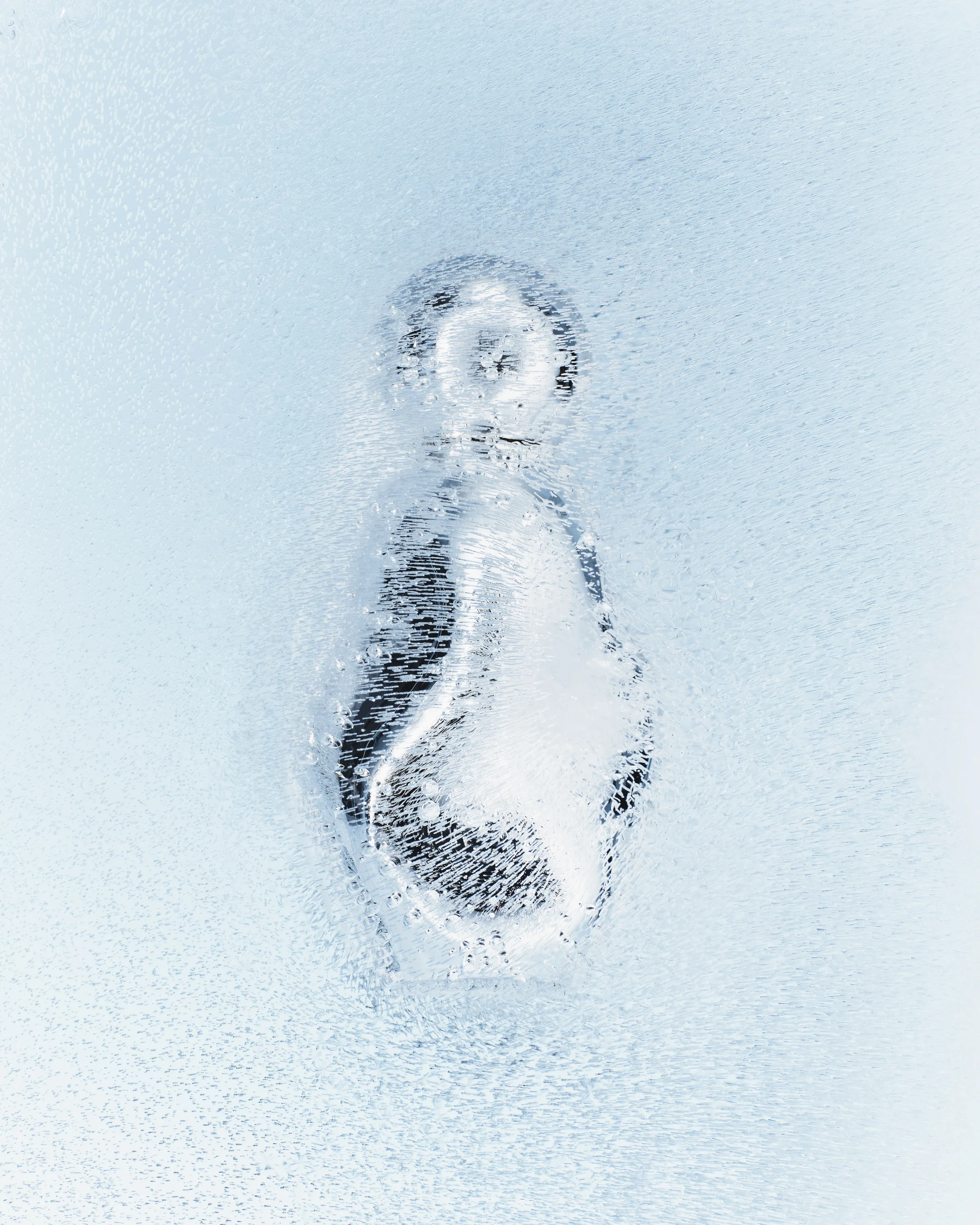Still life of a beauty product frozen inside a block of pale blue ice with trapped bubbles, for Kylie Cosmetics.