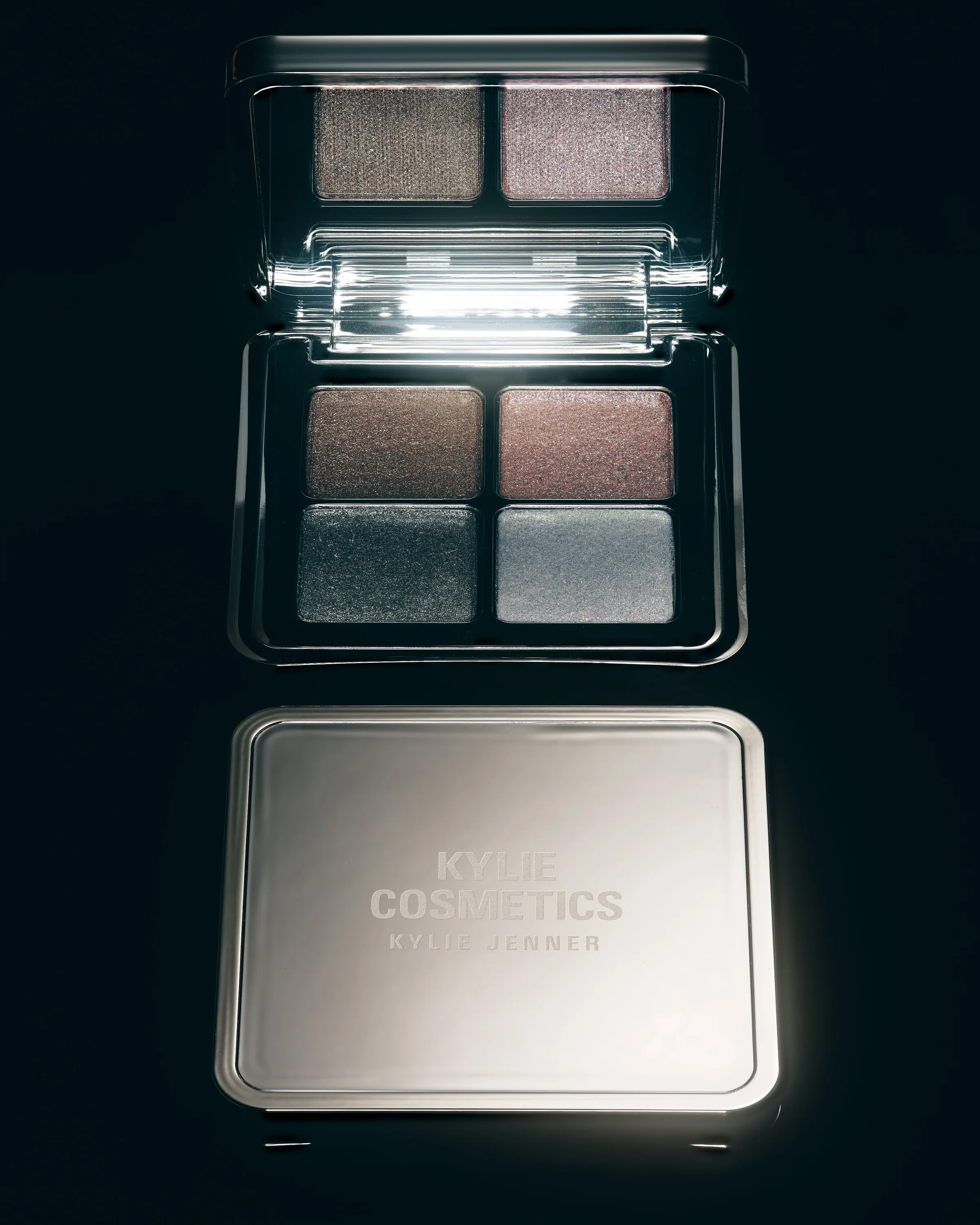 Chrome eyeshadow quad palette shown open above its closed mirrored lid on a black background, for Kylie Cosmetics.