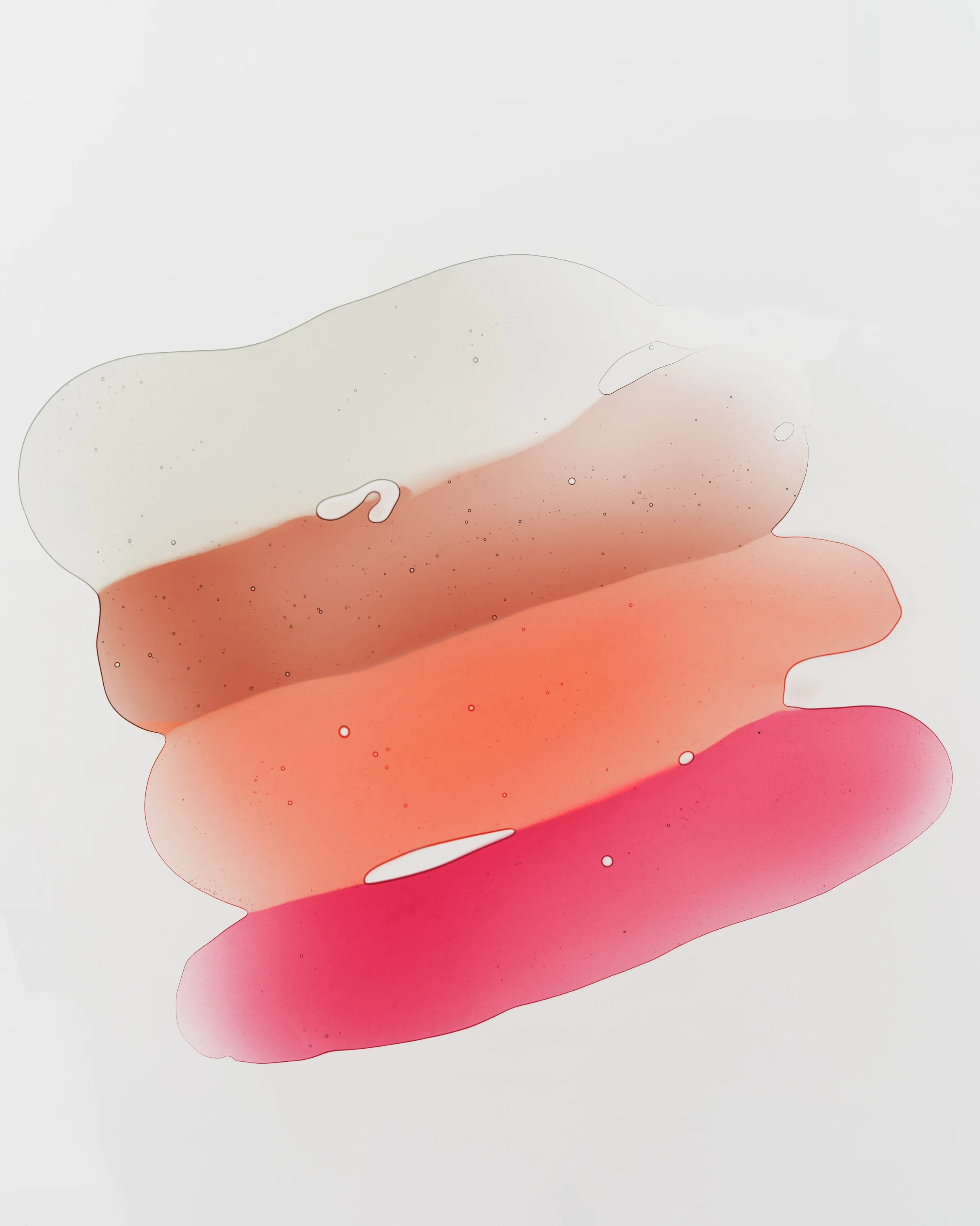 Four translucent lip gloss swatches in clear, brown, coral and pink smeared on a white background, for Kylie Cosmetics.