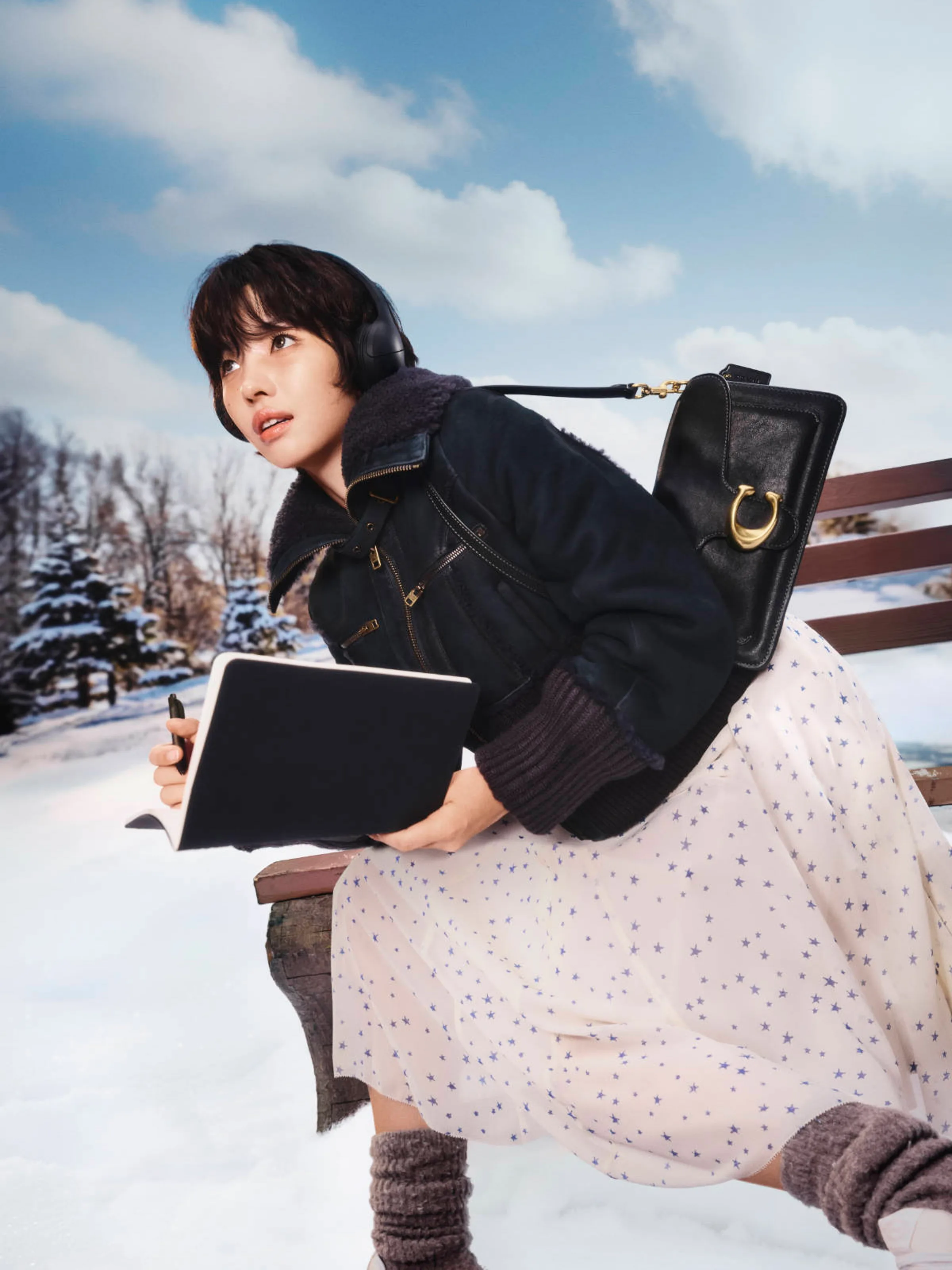AI image of a woman in a shearling jacket and star-print skirt on a snowy bench with a black leather bag, for Coach.