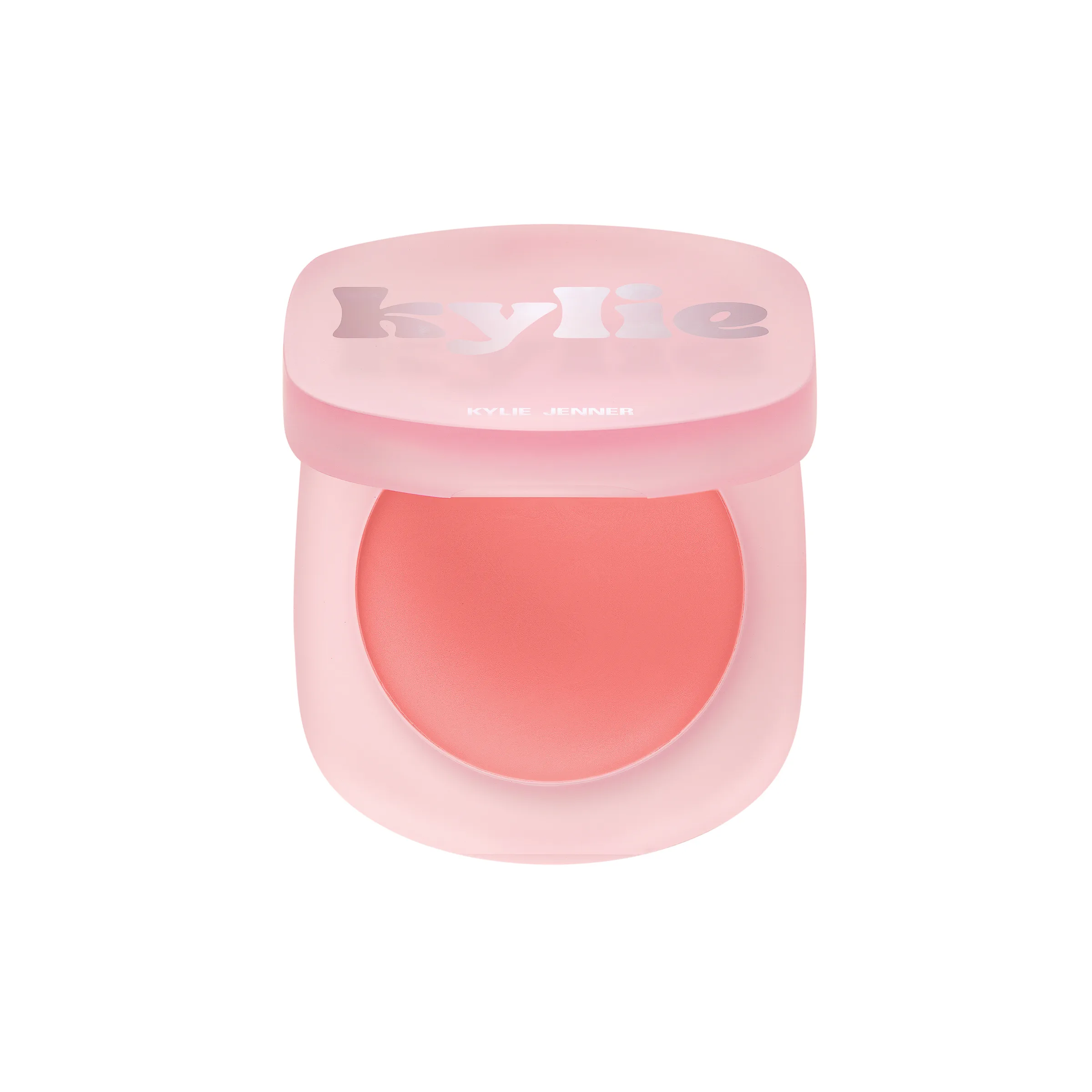 Open pink frosted compact of coral cream blush with silver kylie lettering on a white background, for Kylie Cosmetics.