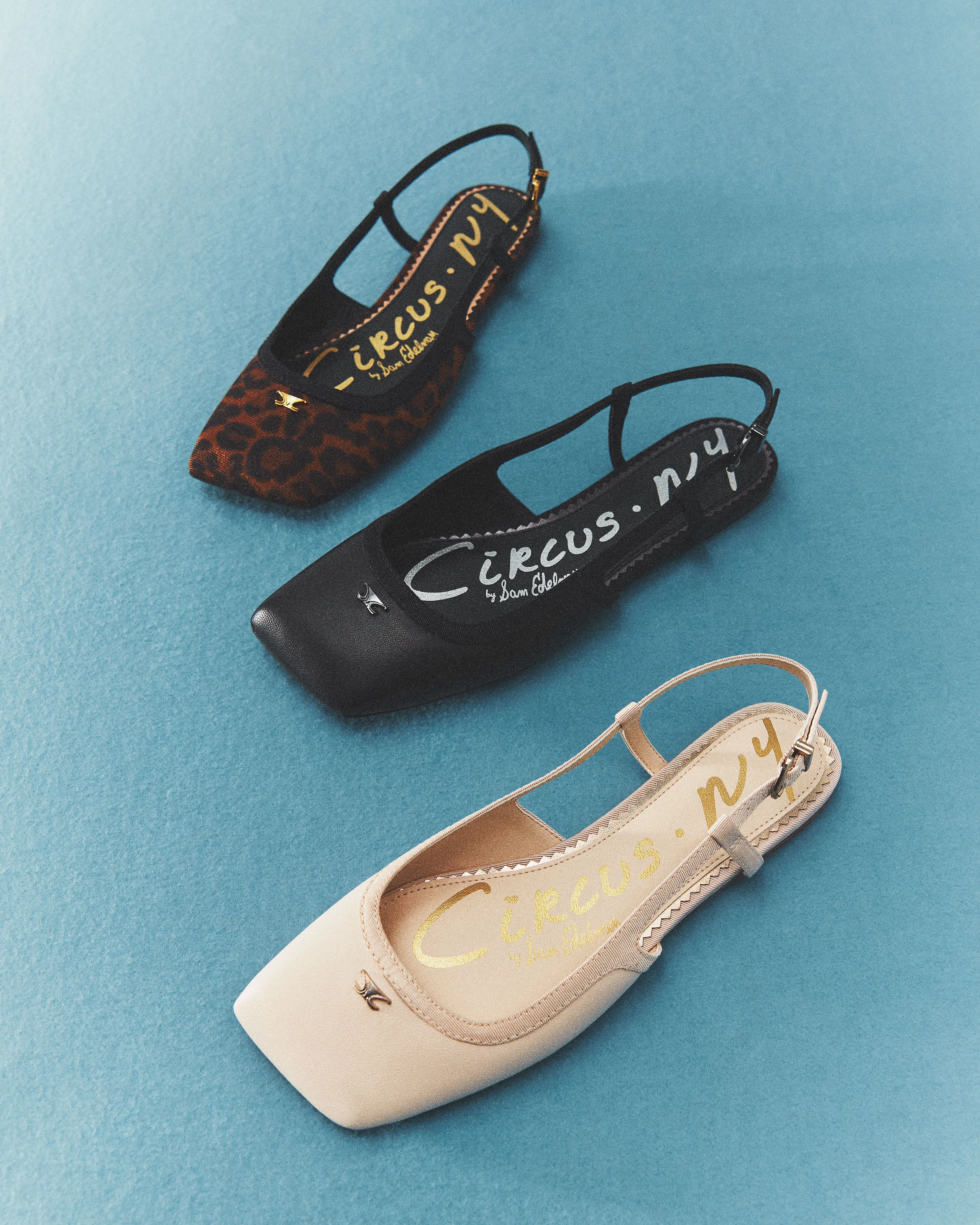 Three square-toe slingback flats in leopard, black and vanilla on a blue textured backdrop, for Circus NY.