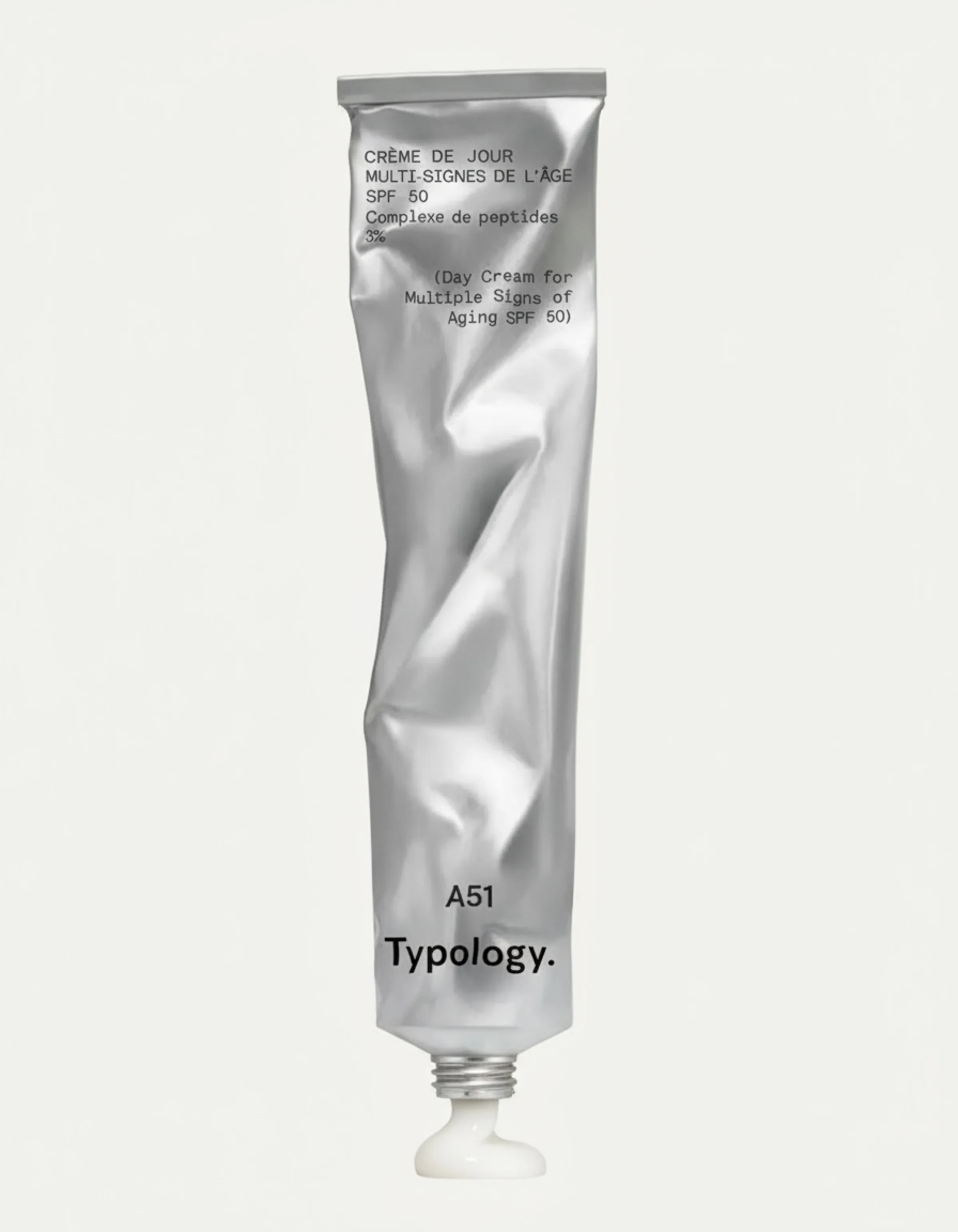 Crumpled silver tube of SPF 50 day cream with a dab of white cream at its open nozzle on an off-white backdrop. Typology AI Concept.