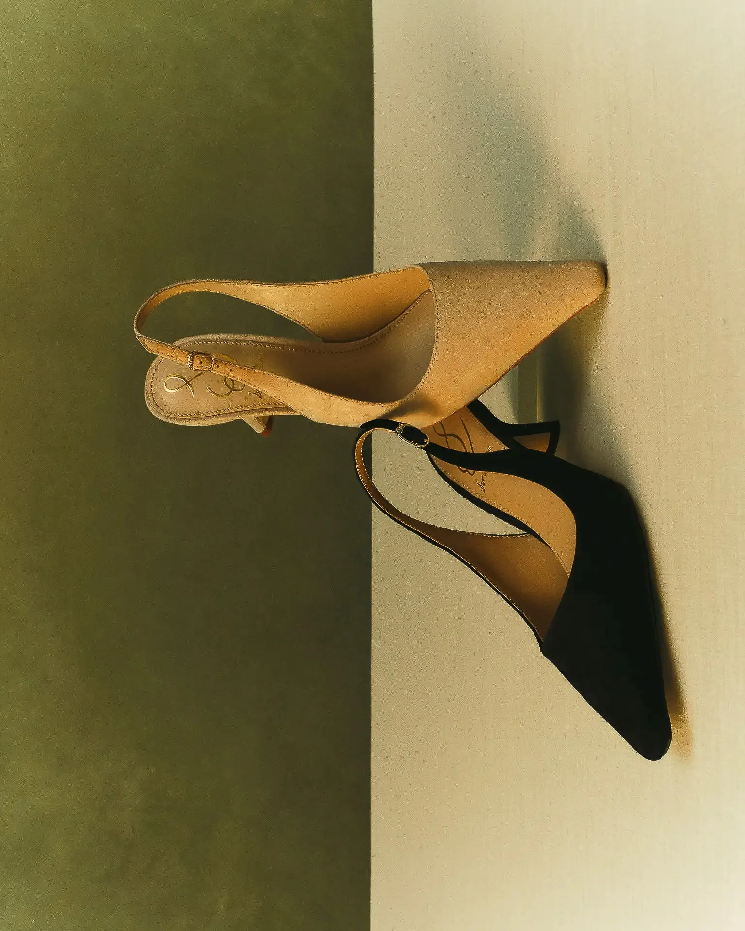 Tan and black pointed slingback heels on a split olive and cream backdrop, shot sideways, for Sam Edelman.