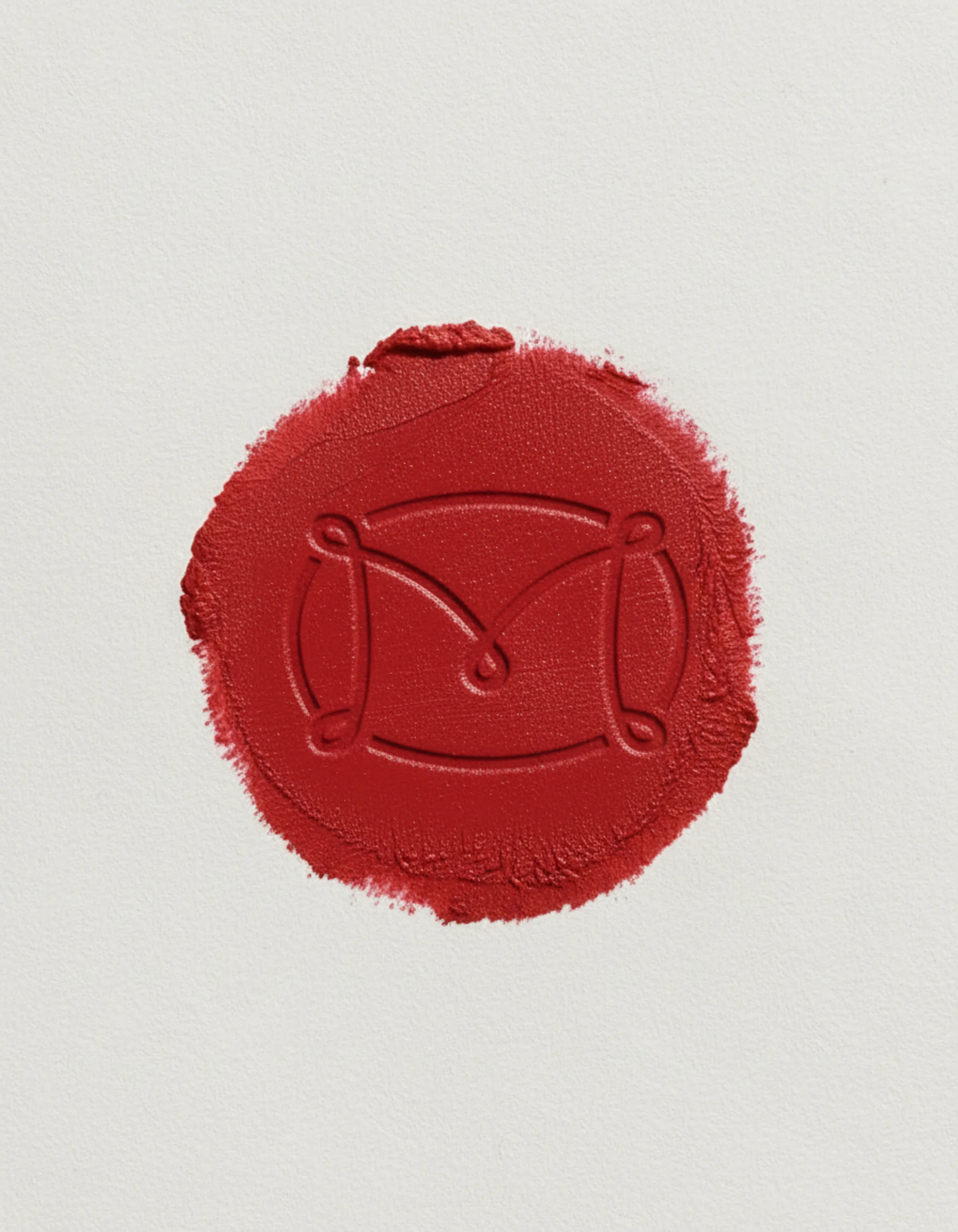 AI image of a red lipstick swatch embossed with the Merit monogram on textured white paper. Merit Beauty AI Concept.