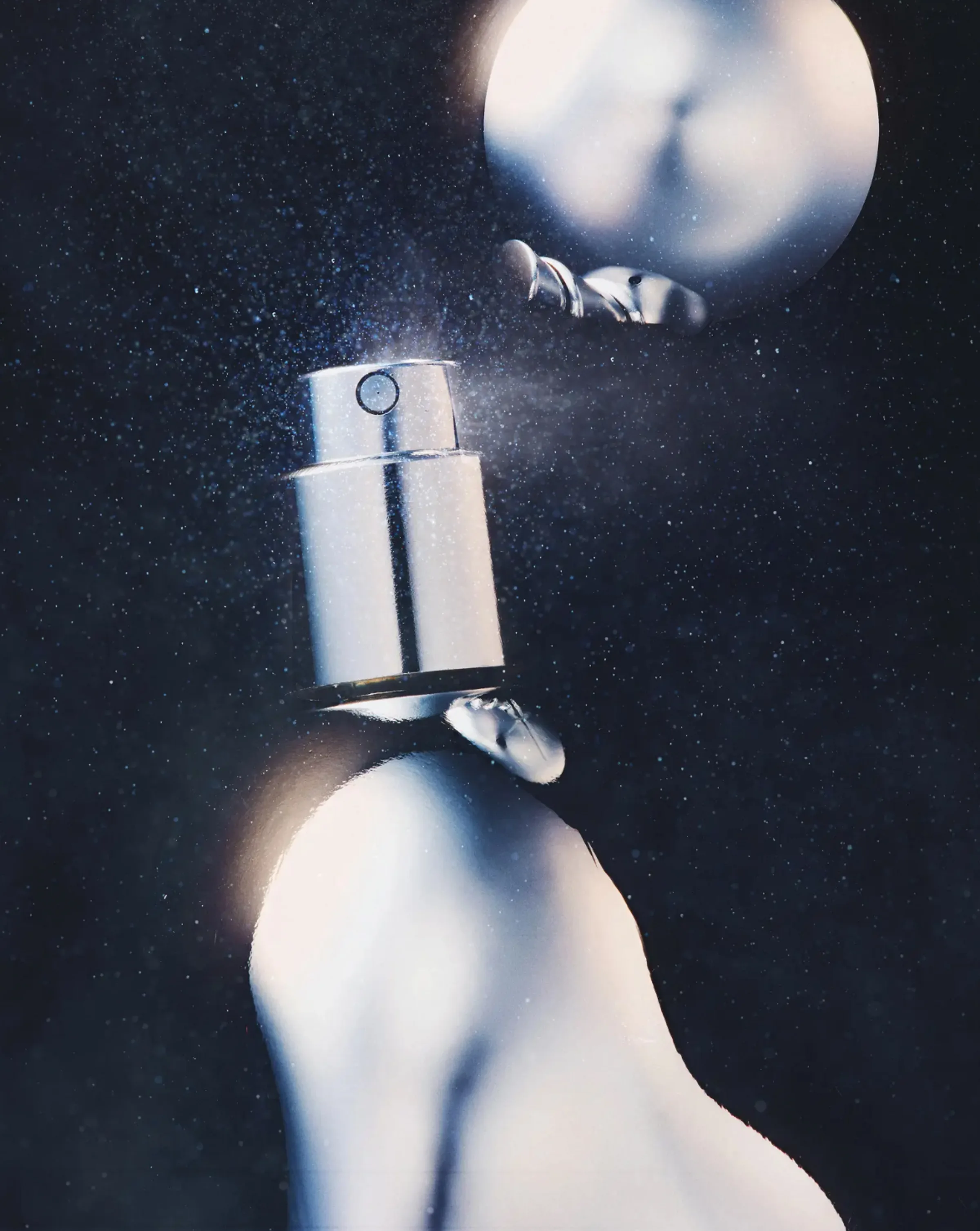 Close-up of a silver fragrance atomizer releasing mist against a dark starry background, for Kylie Cosmetics.