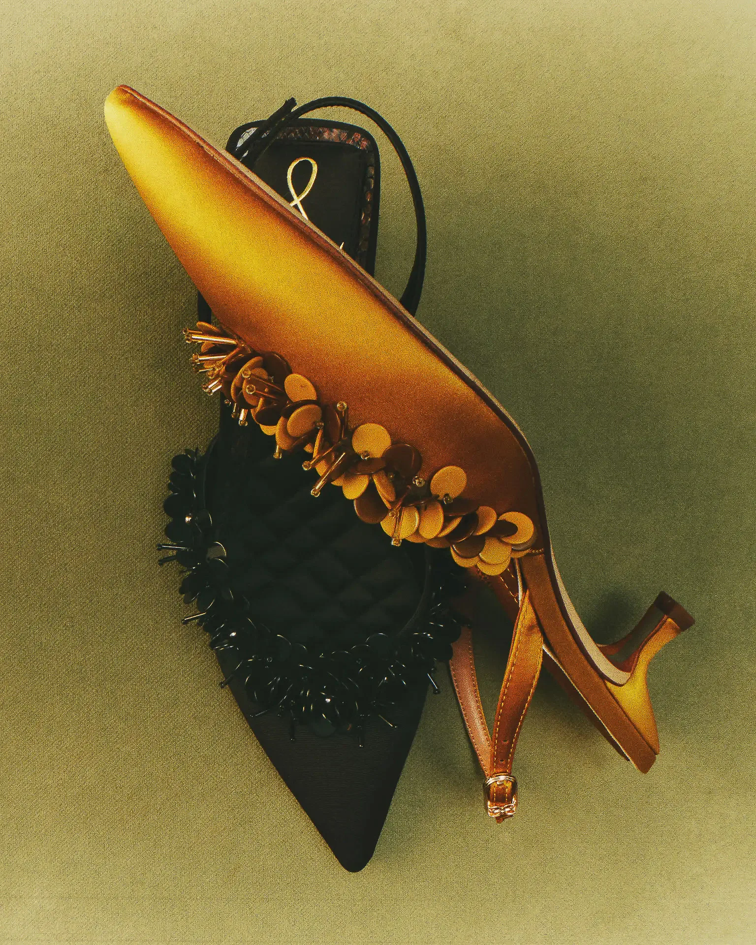 Mustard satin slingback with sequin trim laid over a black beaded pointed flat on an olive backdrop, for Sam Edelman.