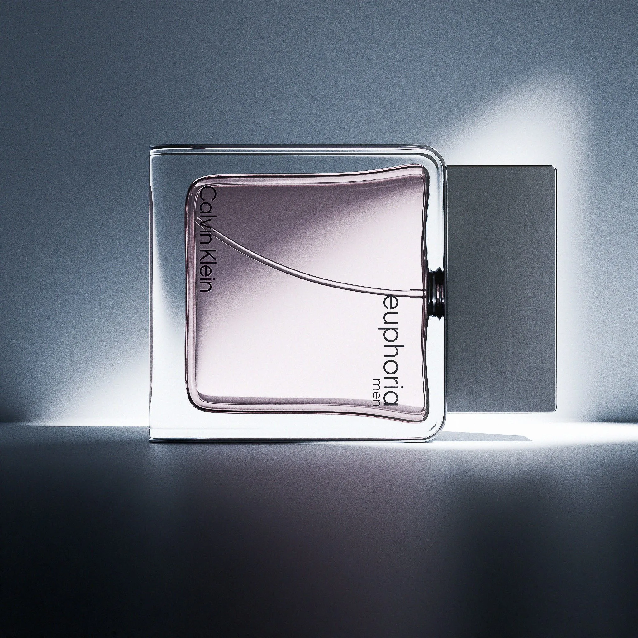 CGI render of a Euphoria Men perfume bottle lying on its side in a beam of cool blue-grey light, for Calvin Klein.