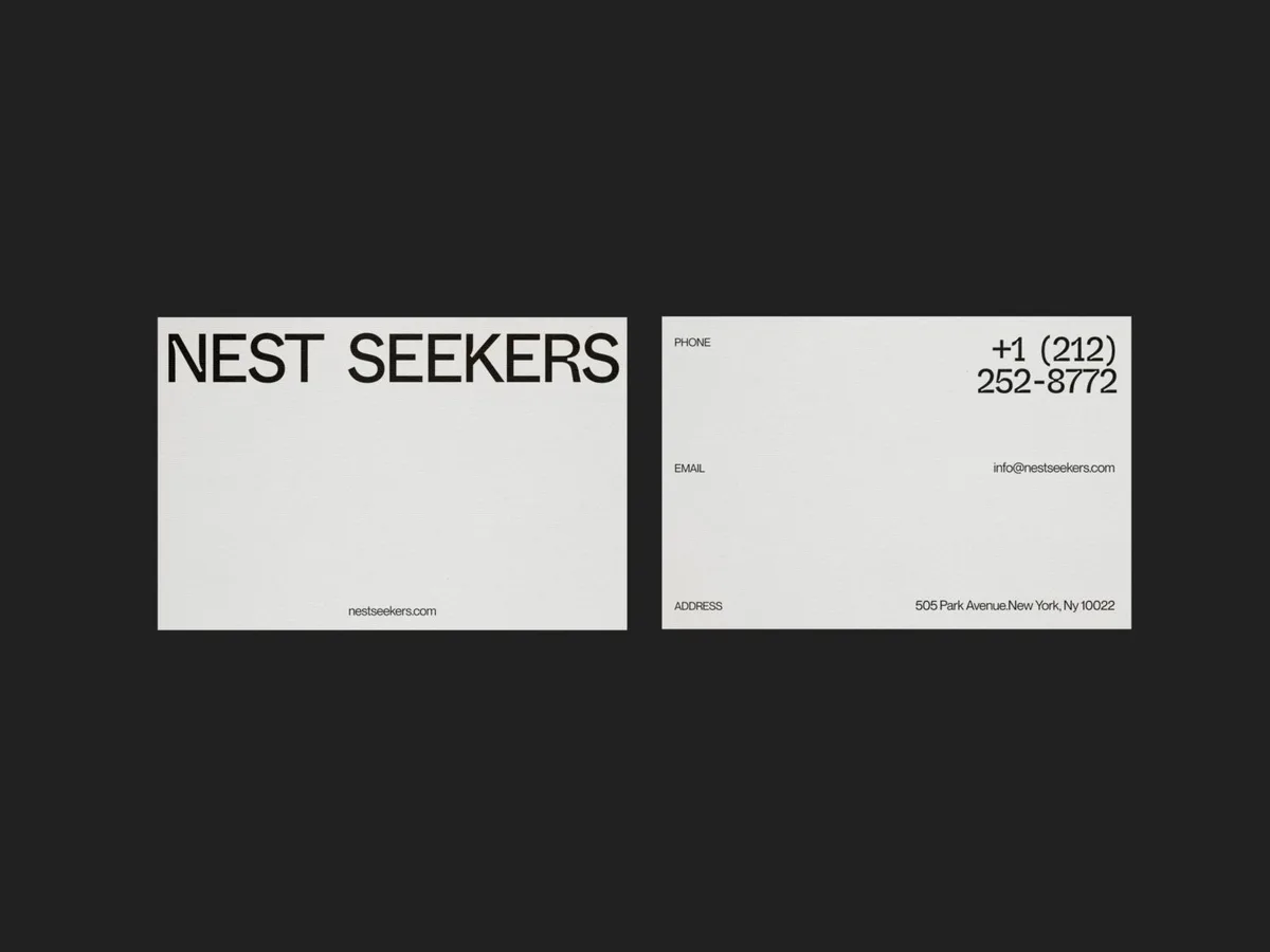 Front and back of white business cards with black wordmark and contact details on a dark background, for Nest Seekers.