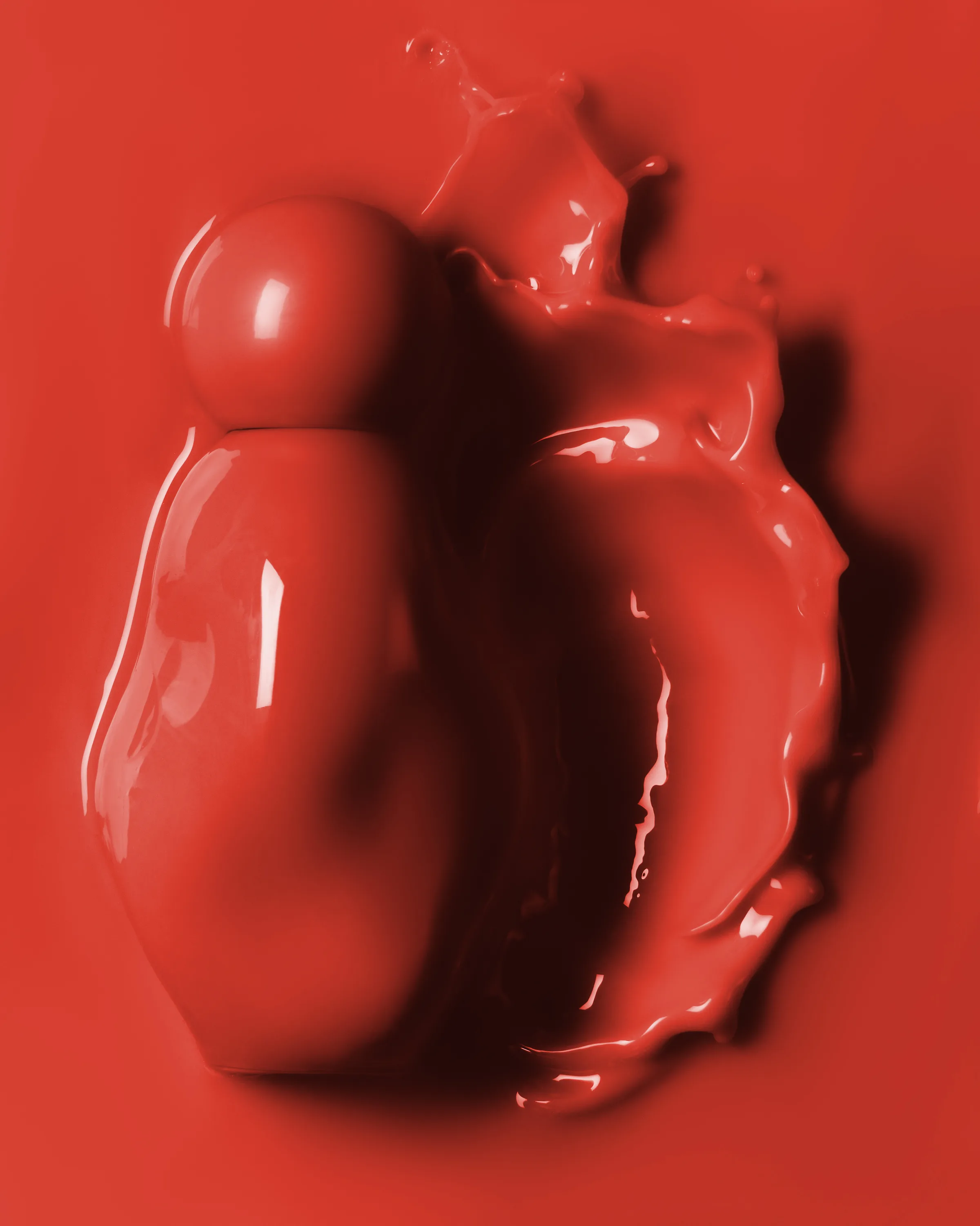 Glossy red perfume bottle submerged in red liquid with a frozen splash curling beside it, for Kylie Cosmetics.